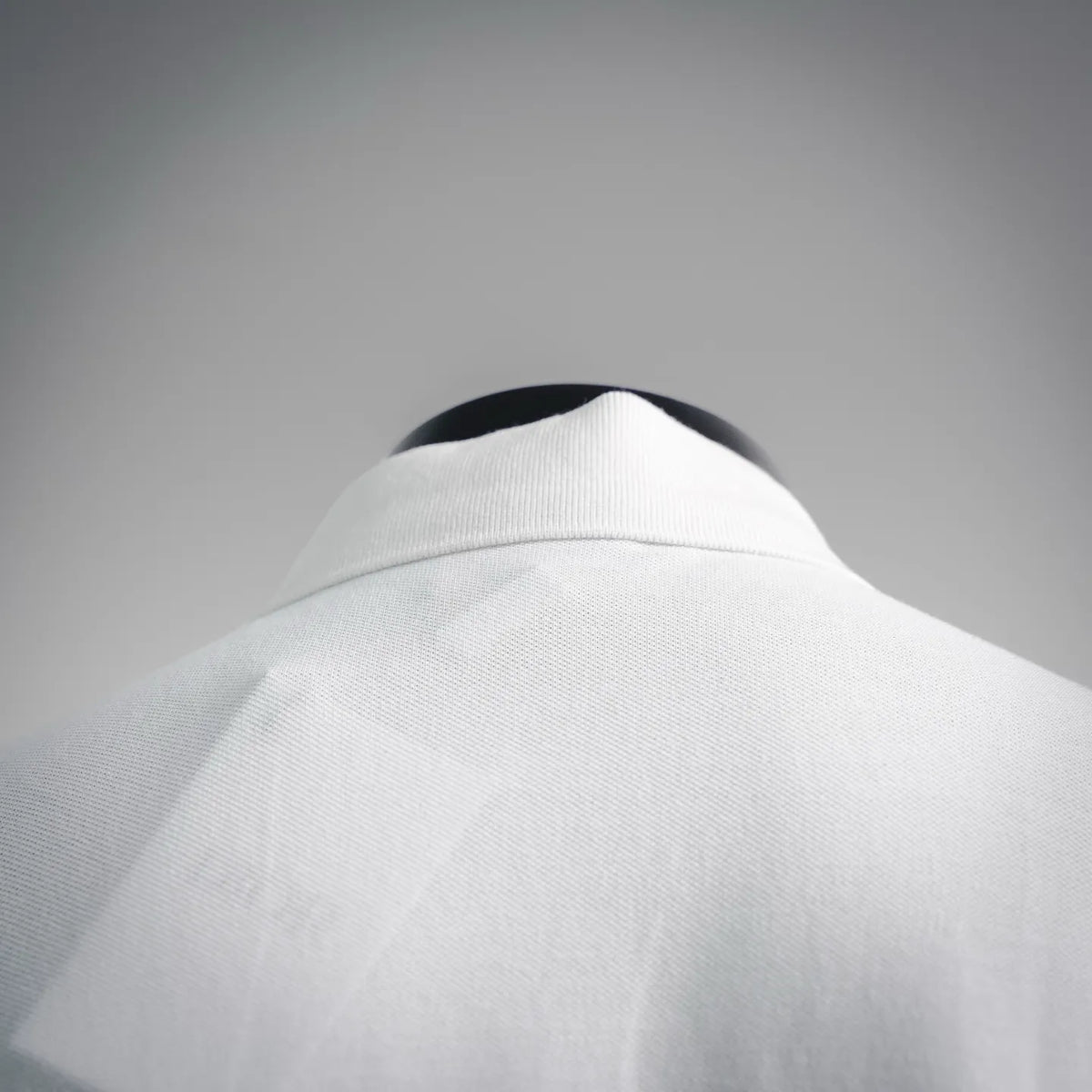 White polo shirt back collar area with smooth texture and structured stand