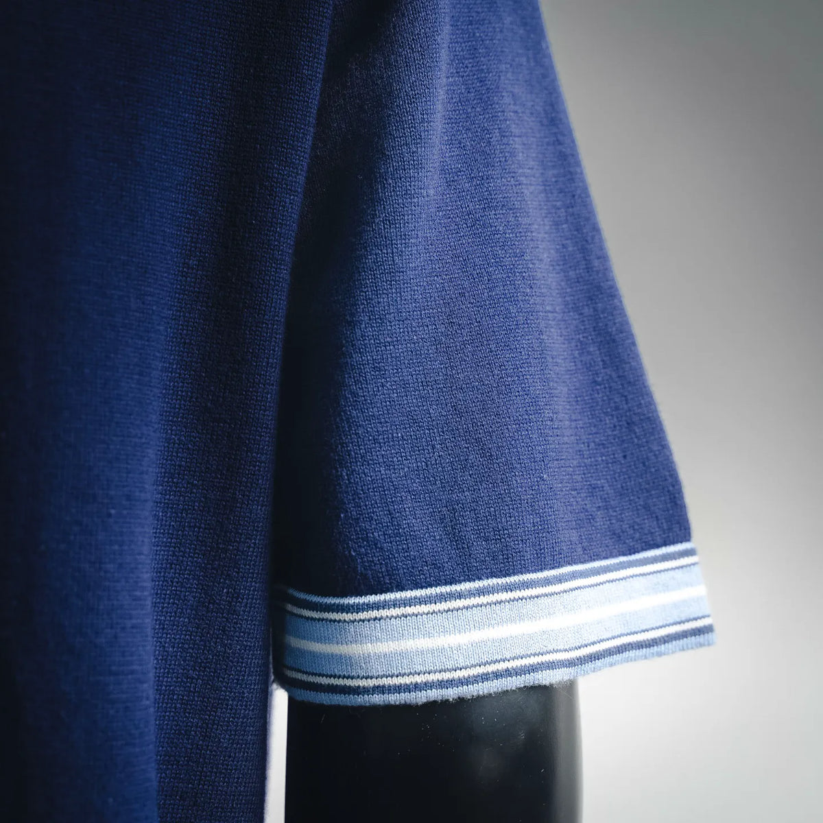 Navy Dior polo shirt sleeve cuff with white and blue striped trim