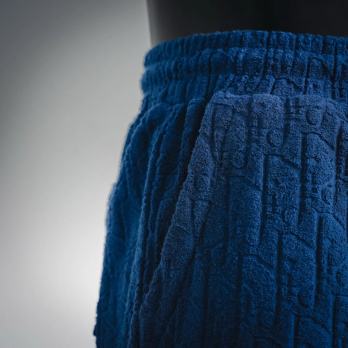 Dior blue textured pants with elastic waistband and gathered drawstring hood