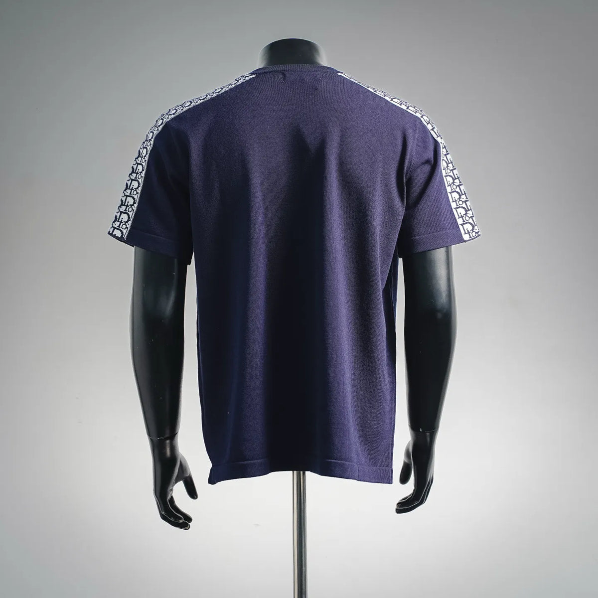 Navy short-sleeve T-shirt, back view with Dior logo trim along sleeve cuffs.