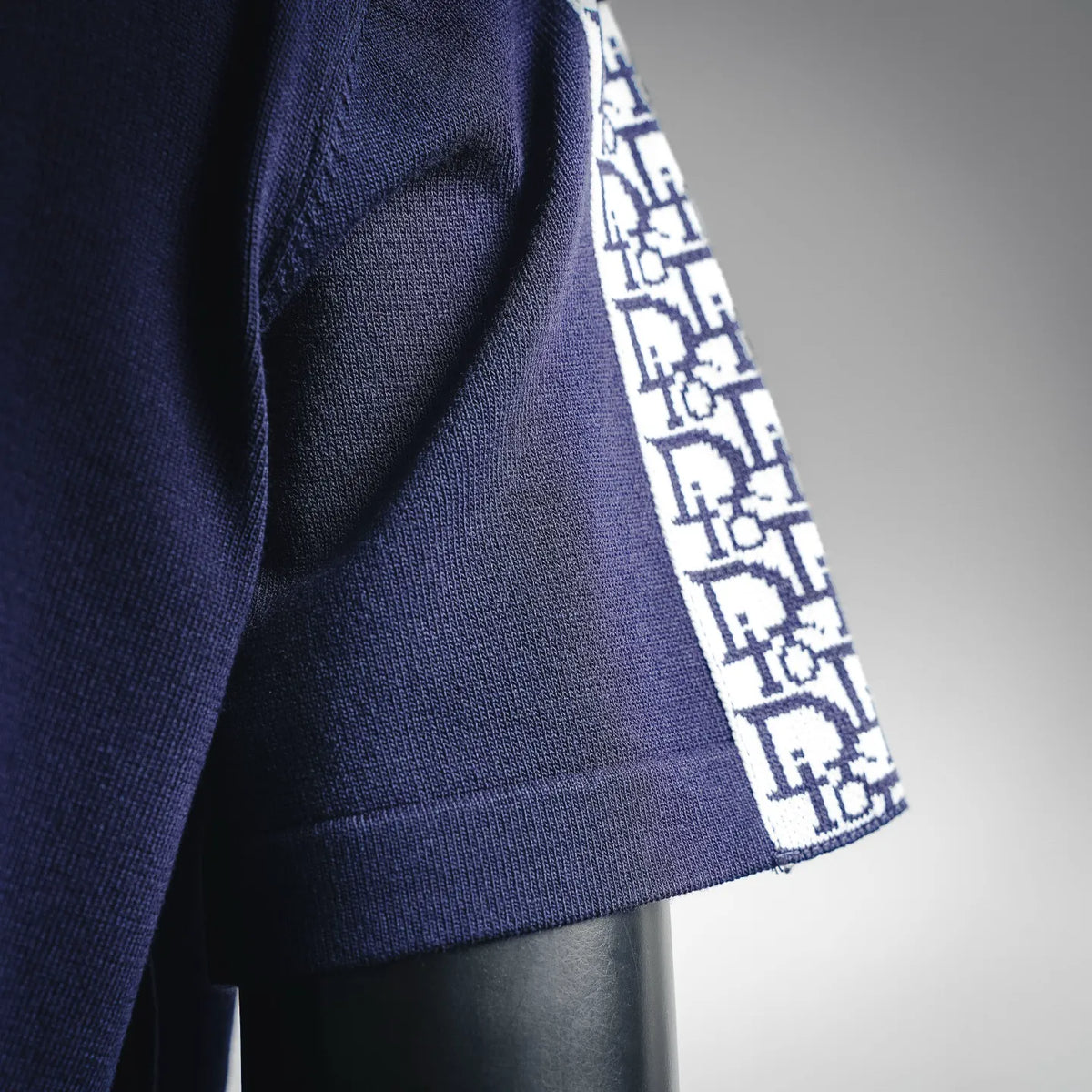 Navy sleeve cuff with white Dior logo pattern trim.
