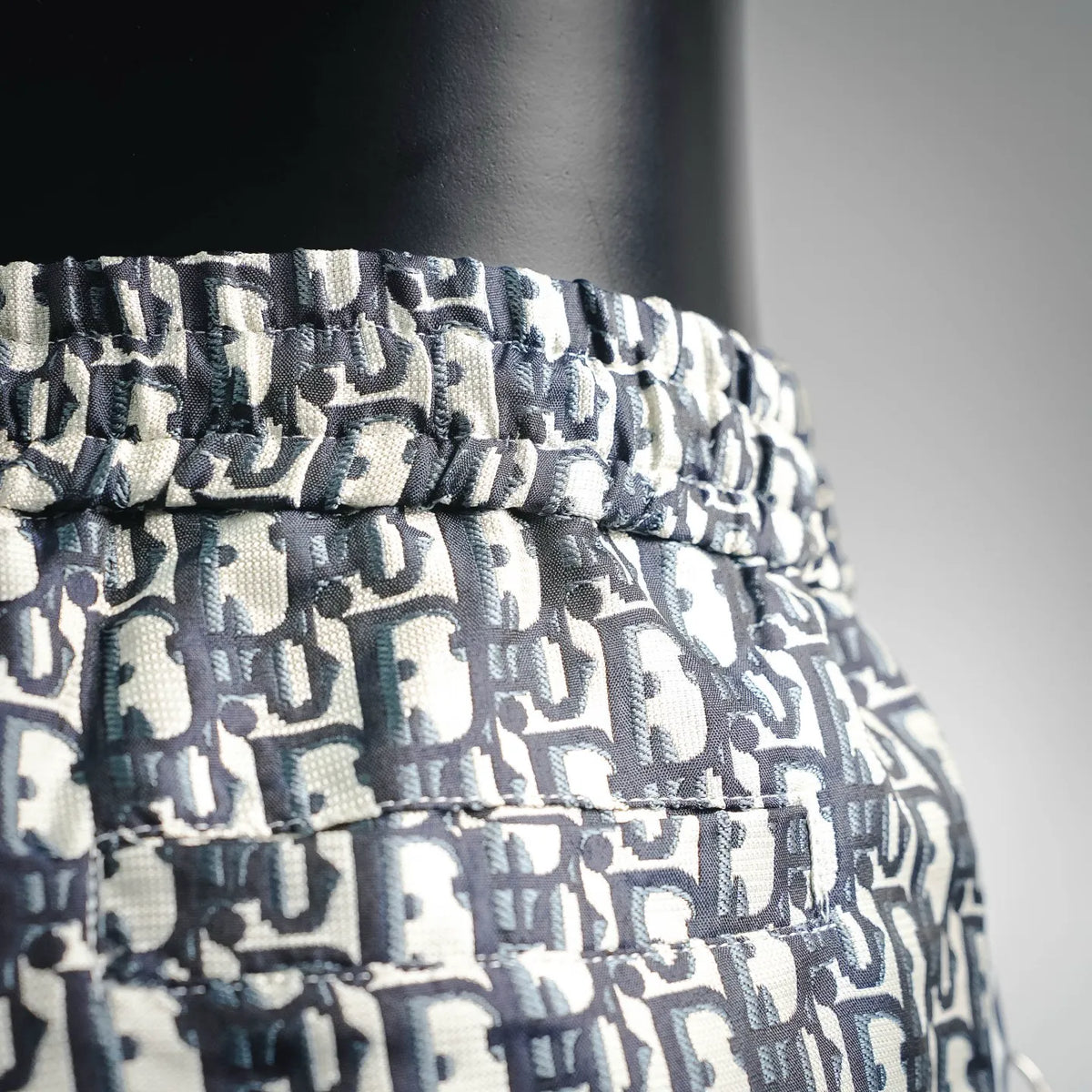 Dior monogram shorts waistband close-up, dark navy and cream woven pattern