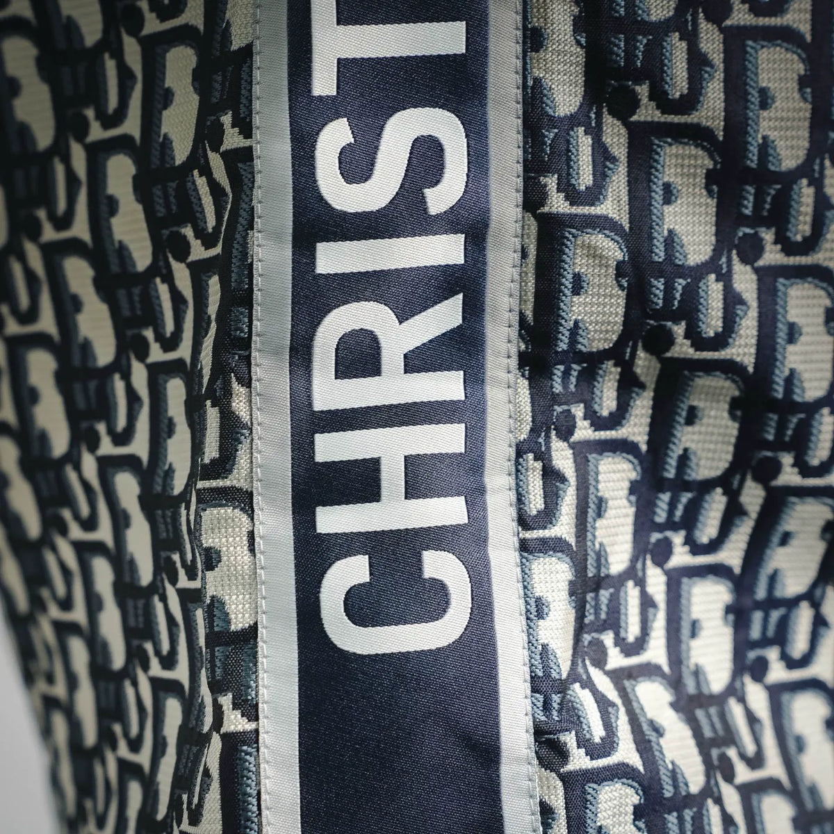 Vertical logo trim on Dior monogram shorts, navy and cream fabric panel
