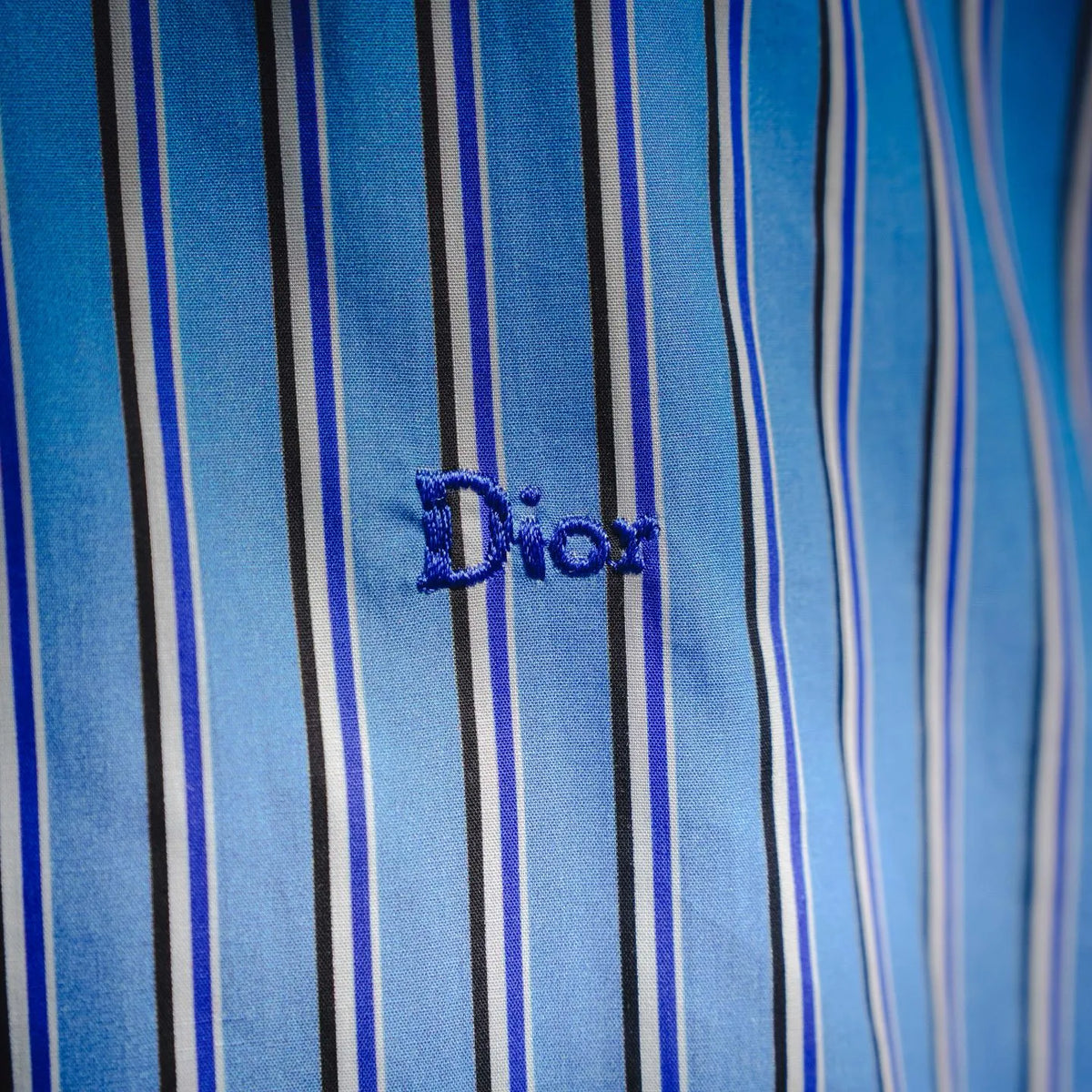Embroidered Dior logo on blue and white striped shirt chest