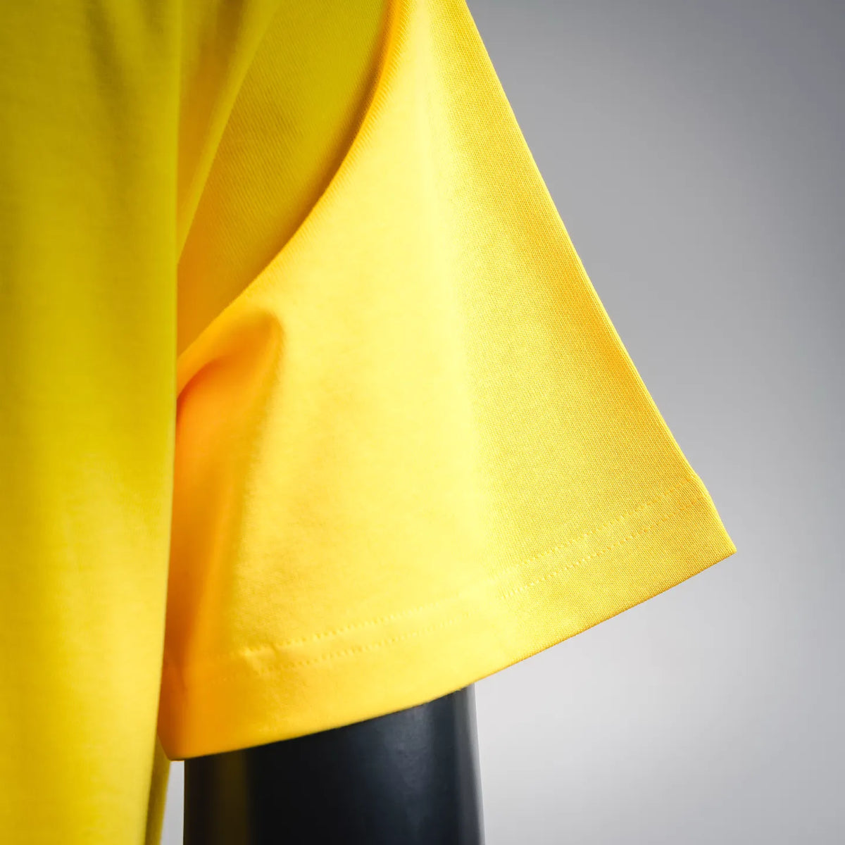 Yellow T-shirt sleeve and fabric drape detail, short cuffed hem