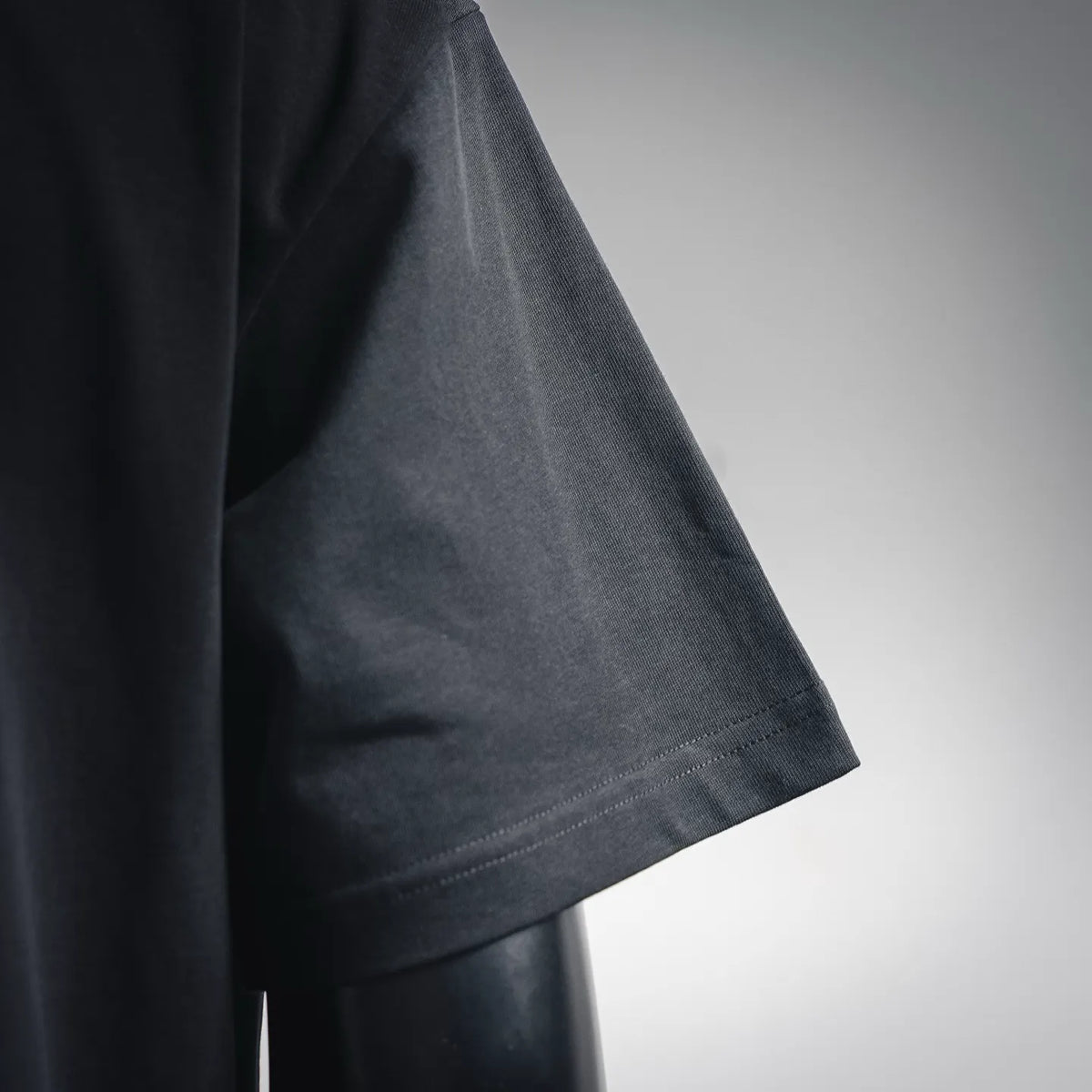 Black T-shirt sleeve with stitched cuff and hem detail