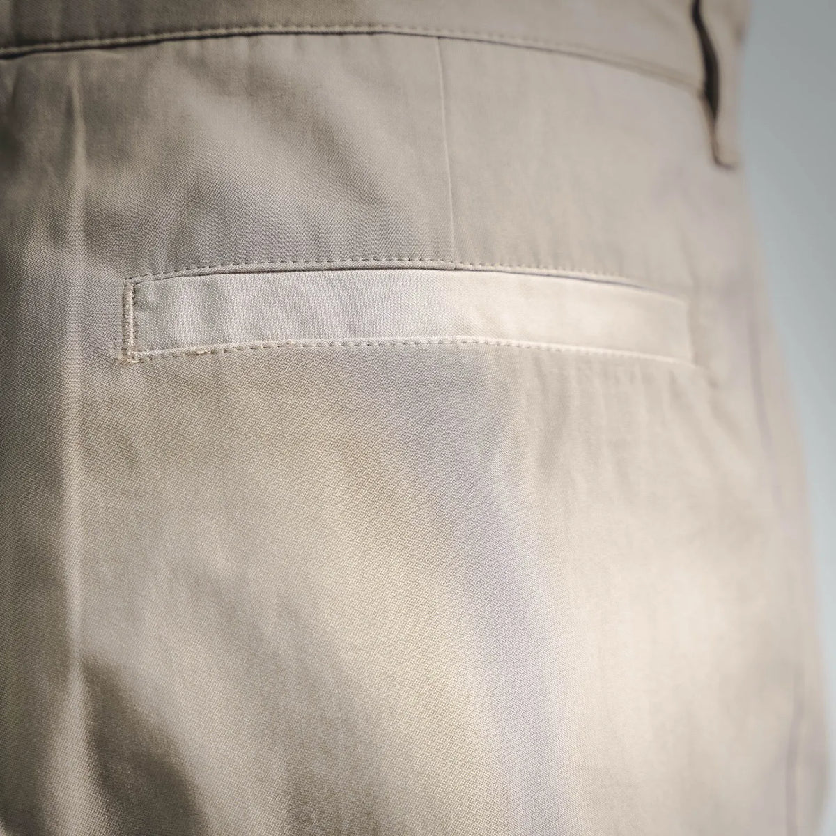 Close-up of tan front pocket with neat topstitching