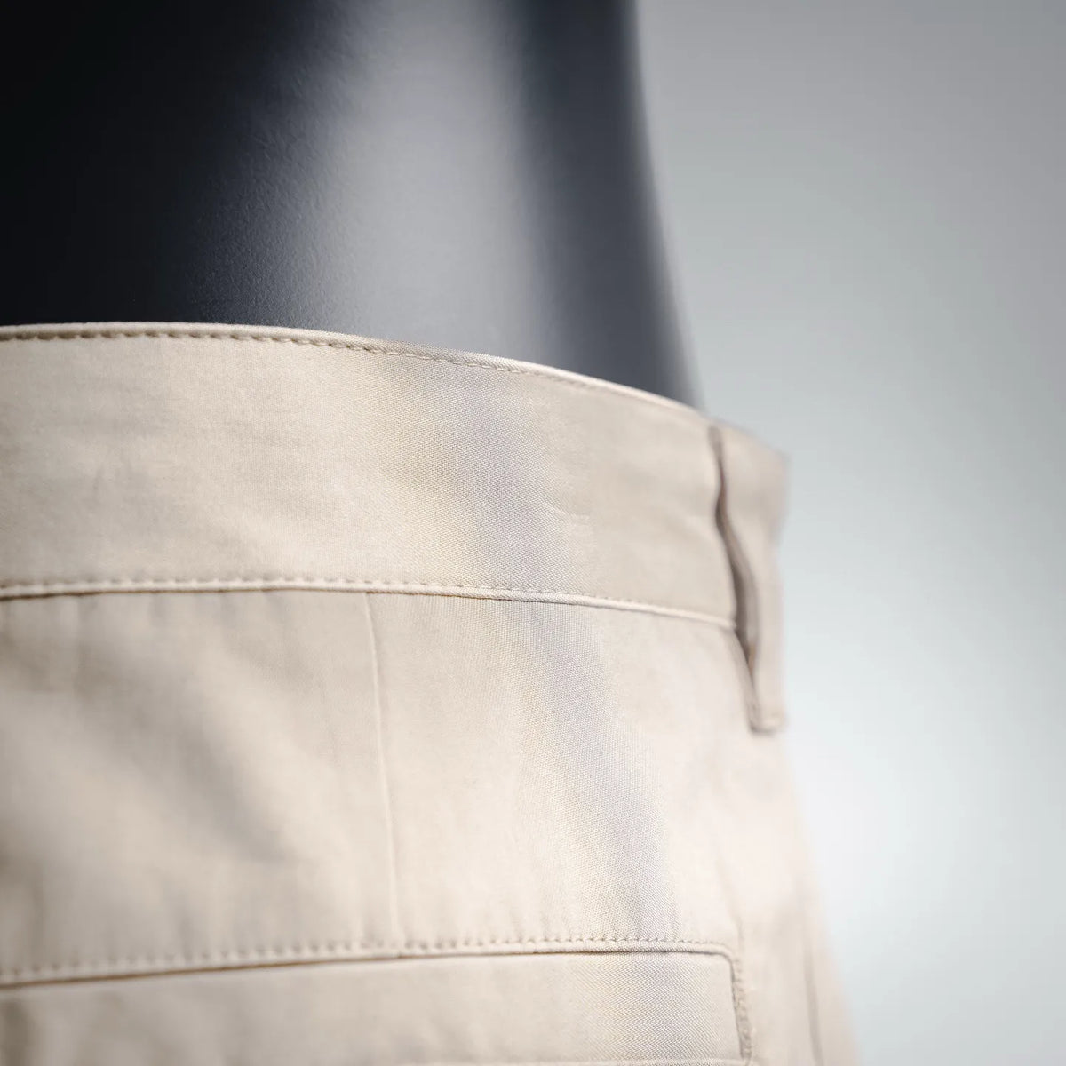 Close-up of tan waistband and belt-loop area with contrast stitching