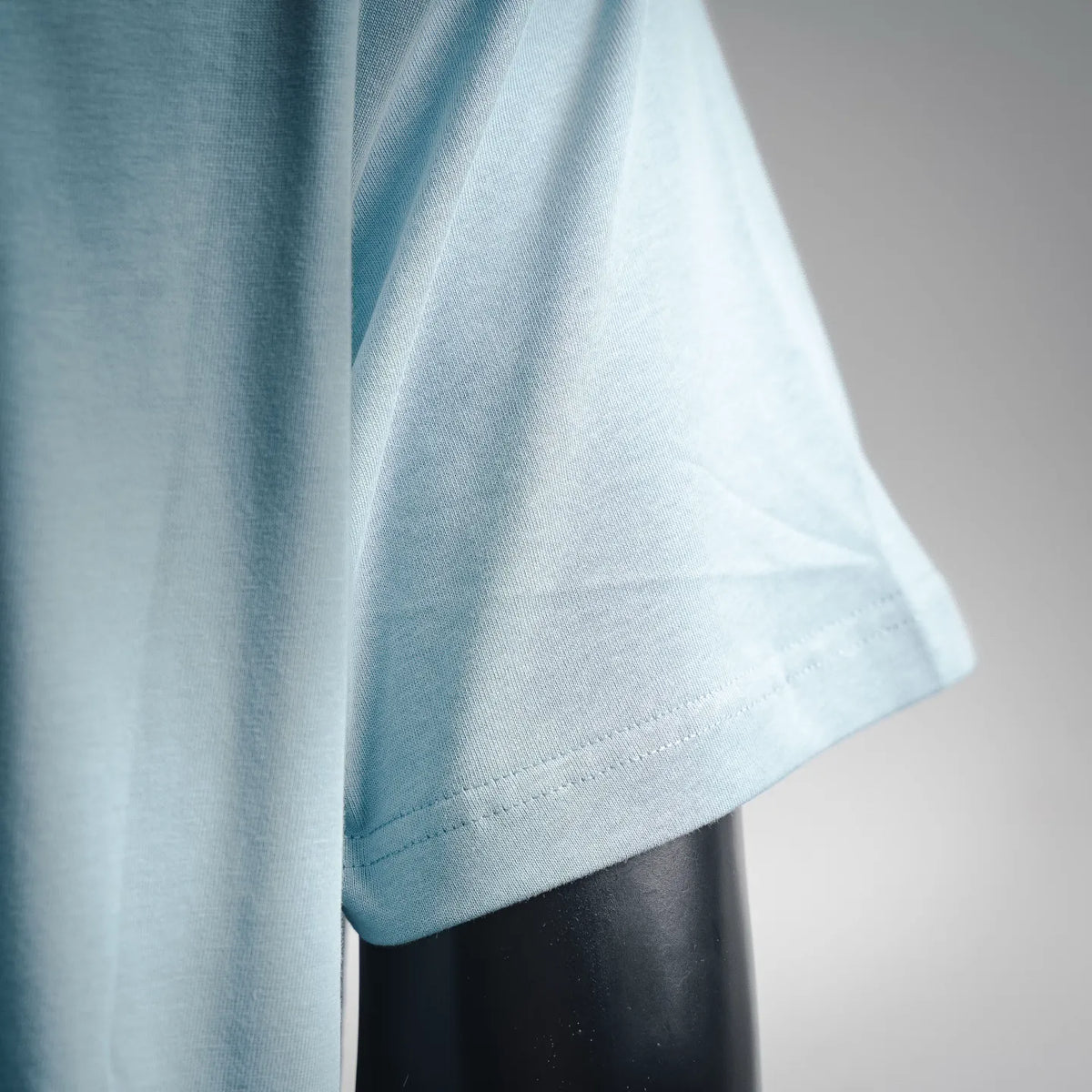 Light blue crew-neck T-shirt with short sleeves and side drape