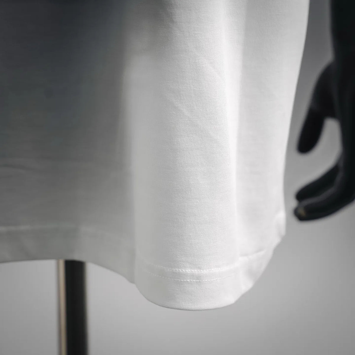 White T-shirt sleeve and hem detail with visible stitching