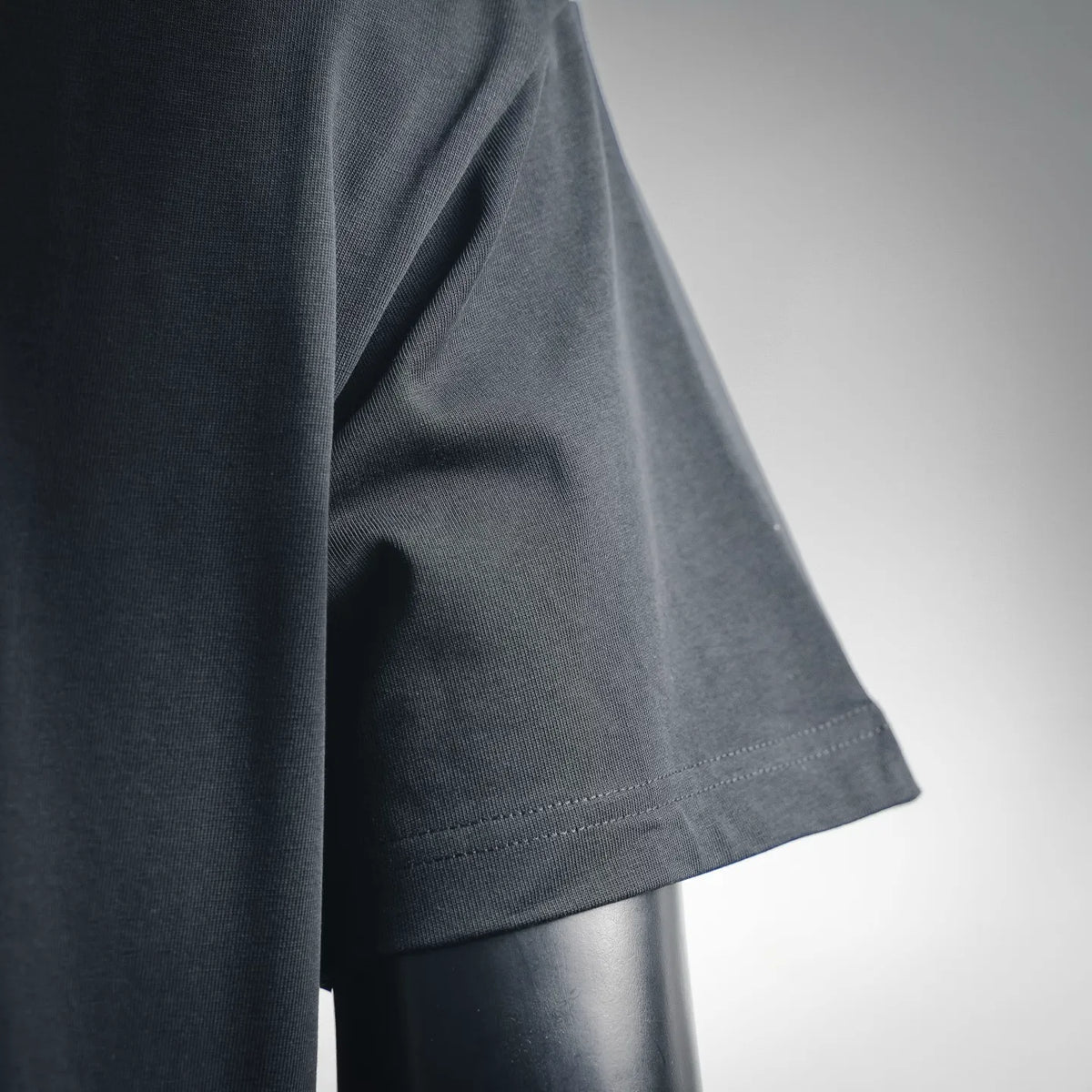 Black T-shirt side close-up at hem edge with stitched trim