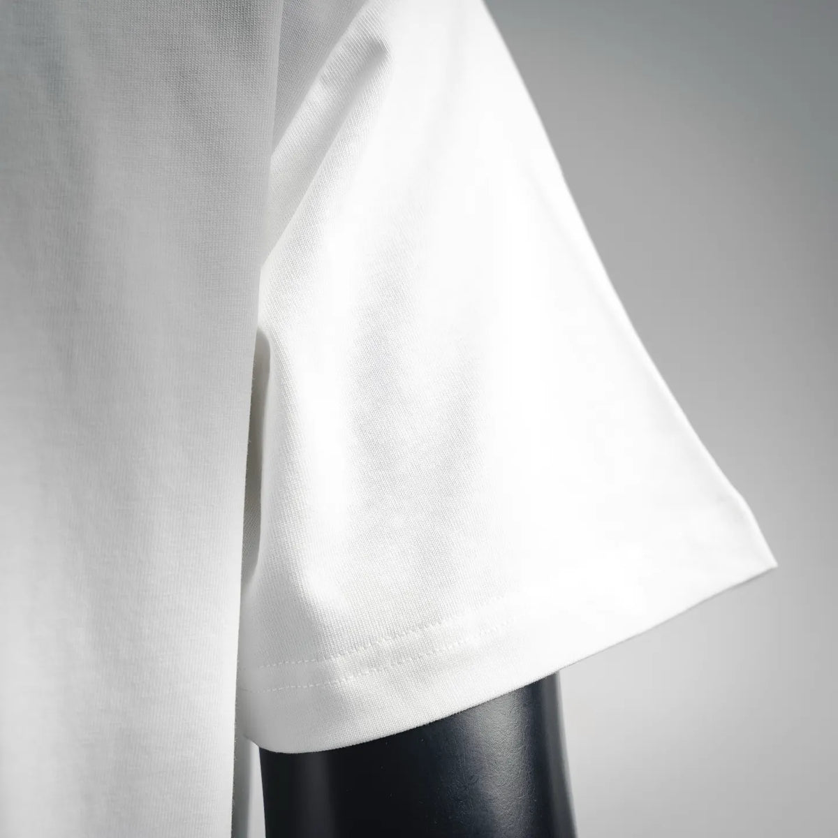 White T-shirt short sleeve and side drape detail on mannequin.
