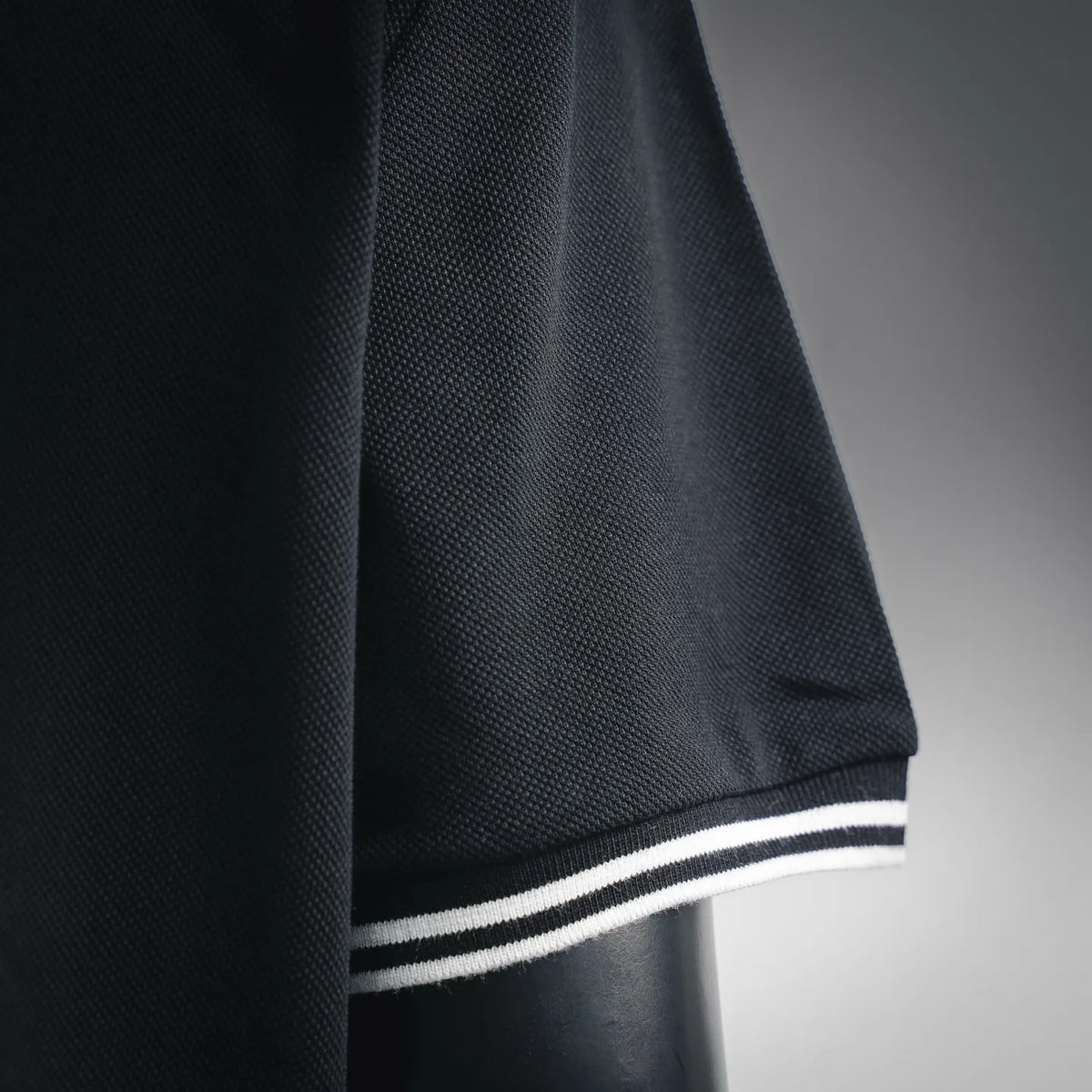Black polo cuff with white-and-black striped trim