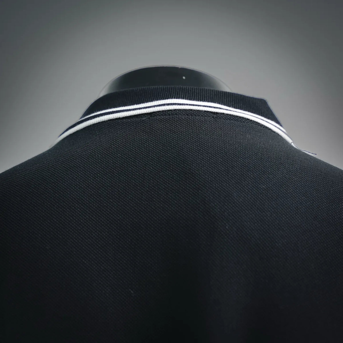 Black polo collar with white double-stripe rib trim