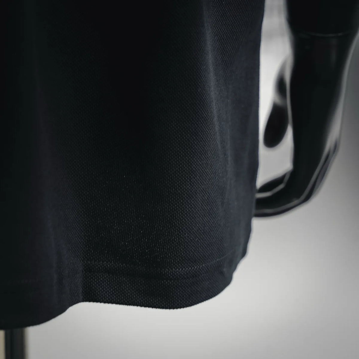 Black polo sleeve hem with small pocket seam