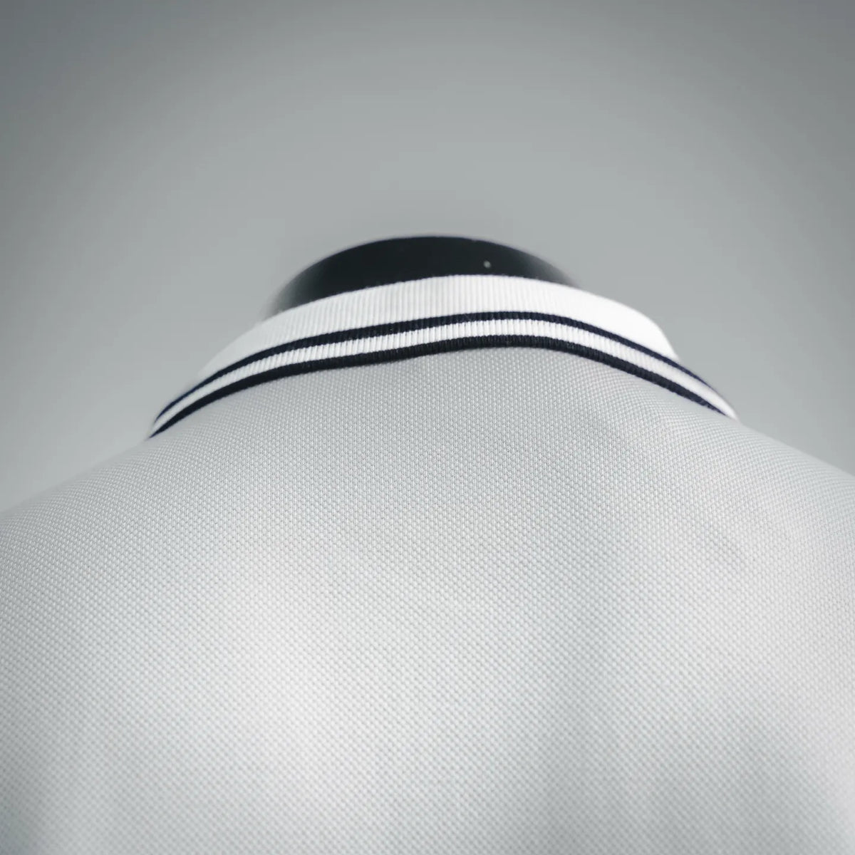 White polo collar with navy-and-white striped trim