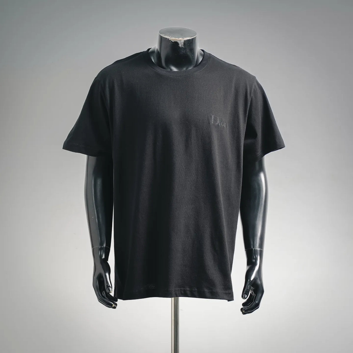 Black Dior short-sleeve T-shirt on mannequin, front view with small chest logo
