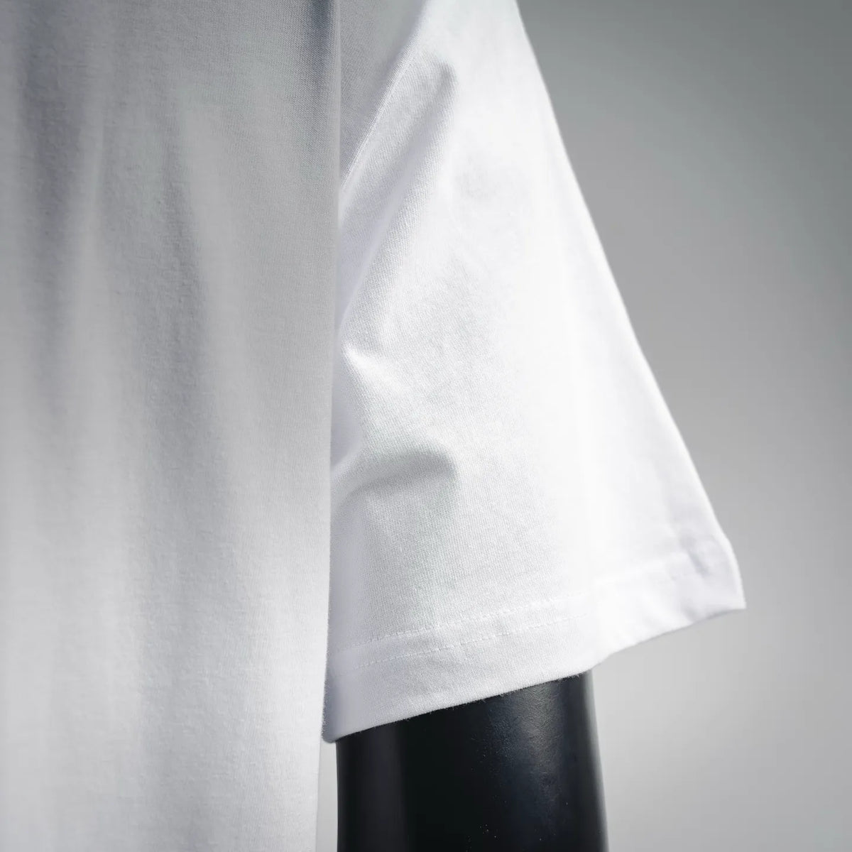 White Dior T-shirt sleeve and hem, close-up side view.