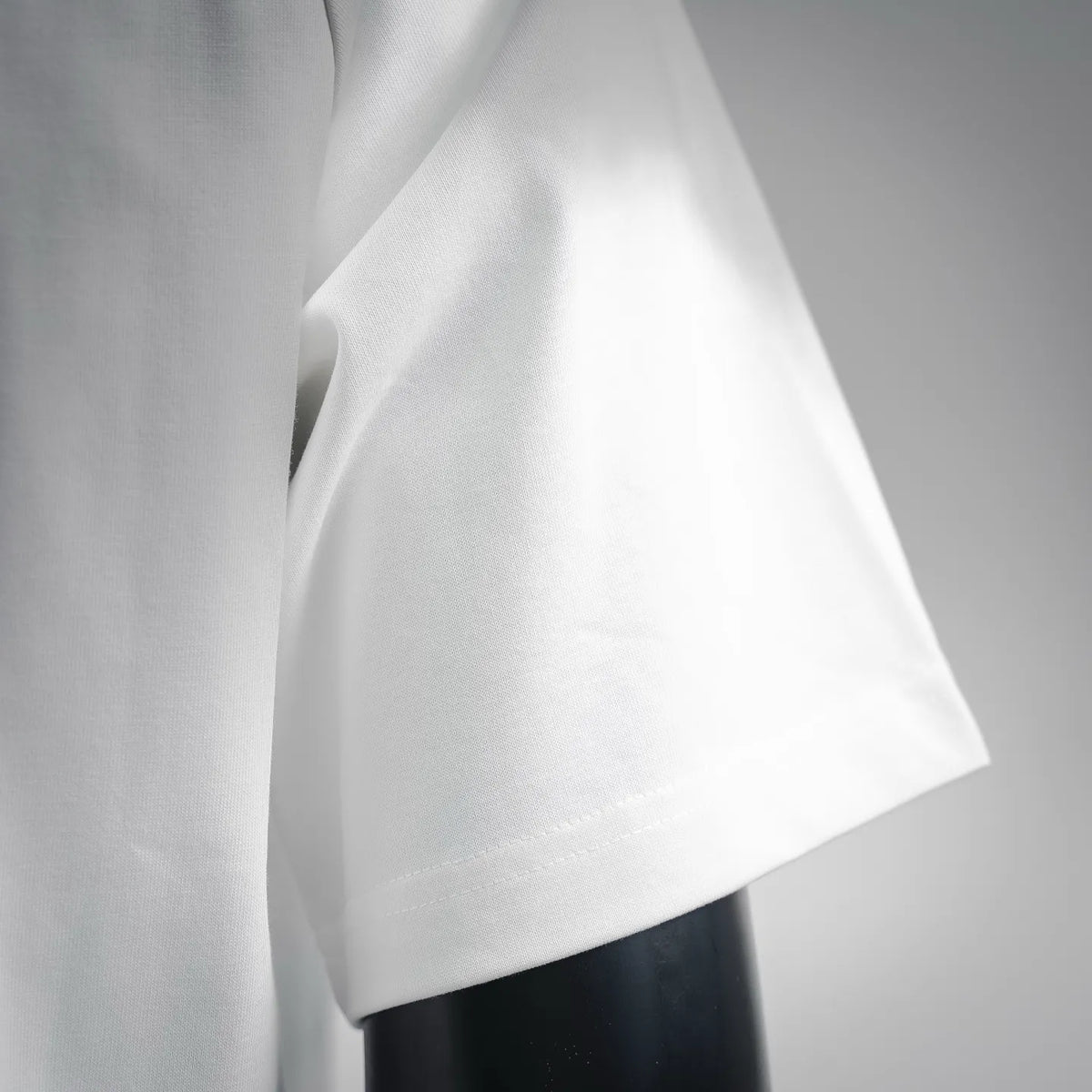 White short-sleeve T-shirt sleeve and curved hem close-up