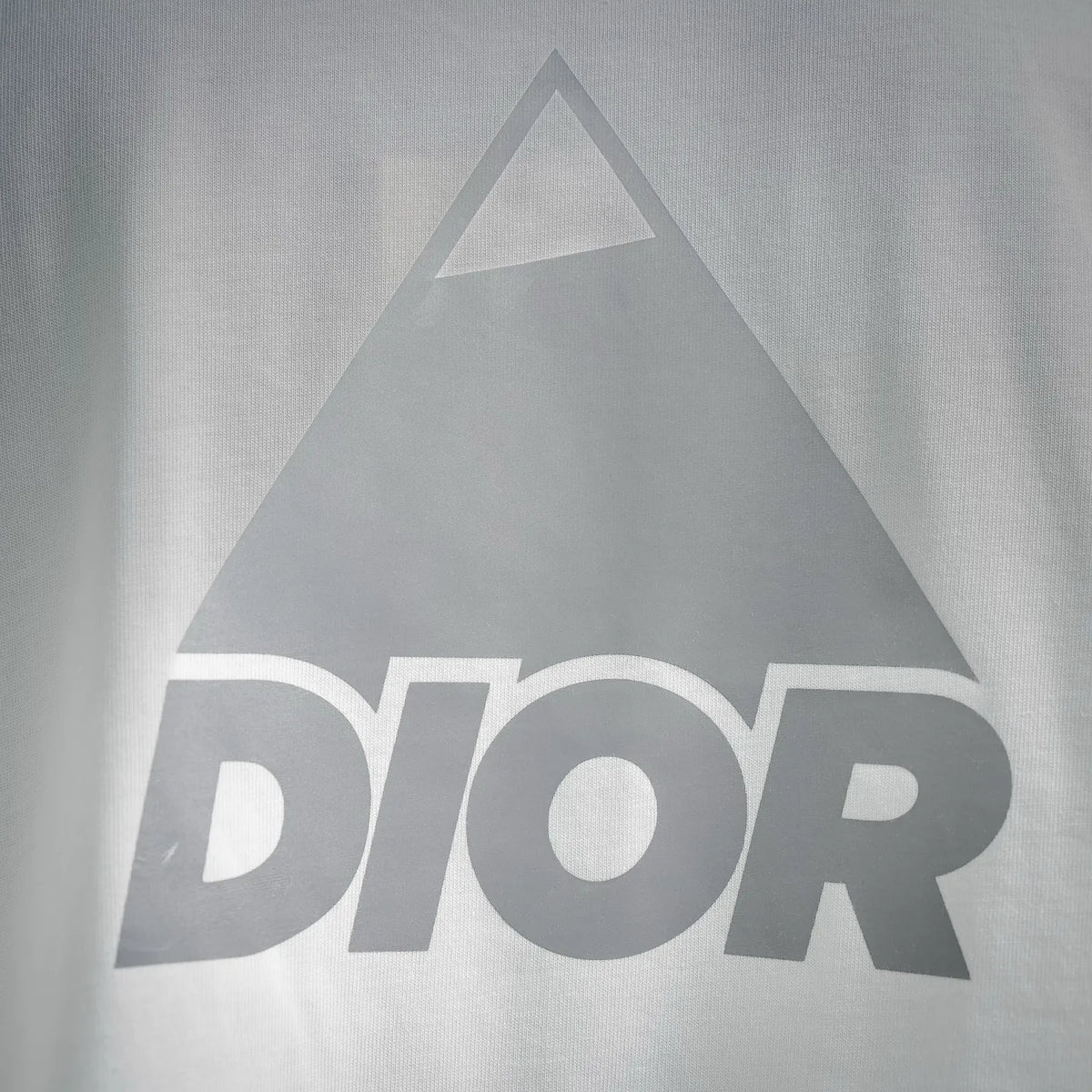 Dior white T-shirt close-up of large triangular Dior graphic