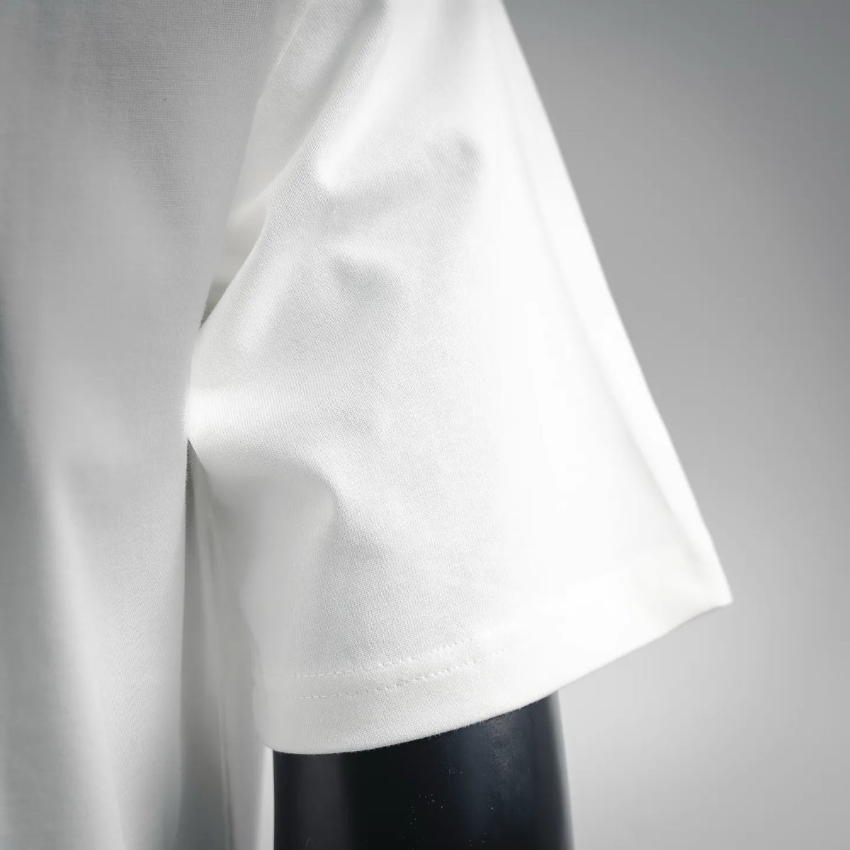 White T-shirt short sleeve cuff and side seam, close-up