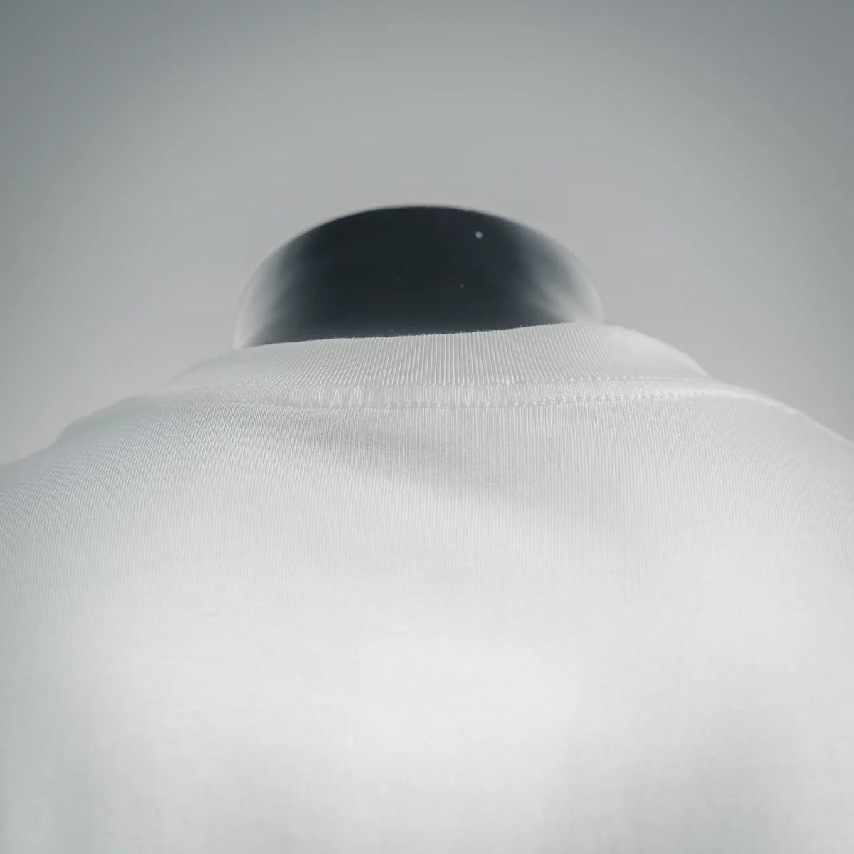 White crewneck T-shirt neckline on mannequin, collar close-up