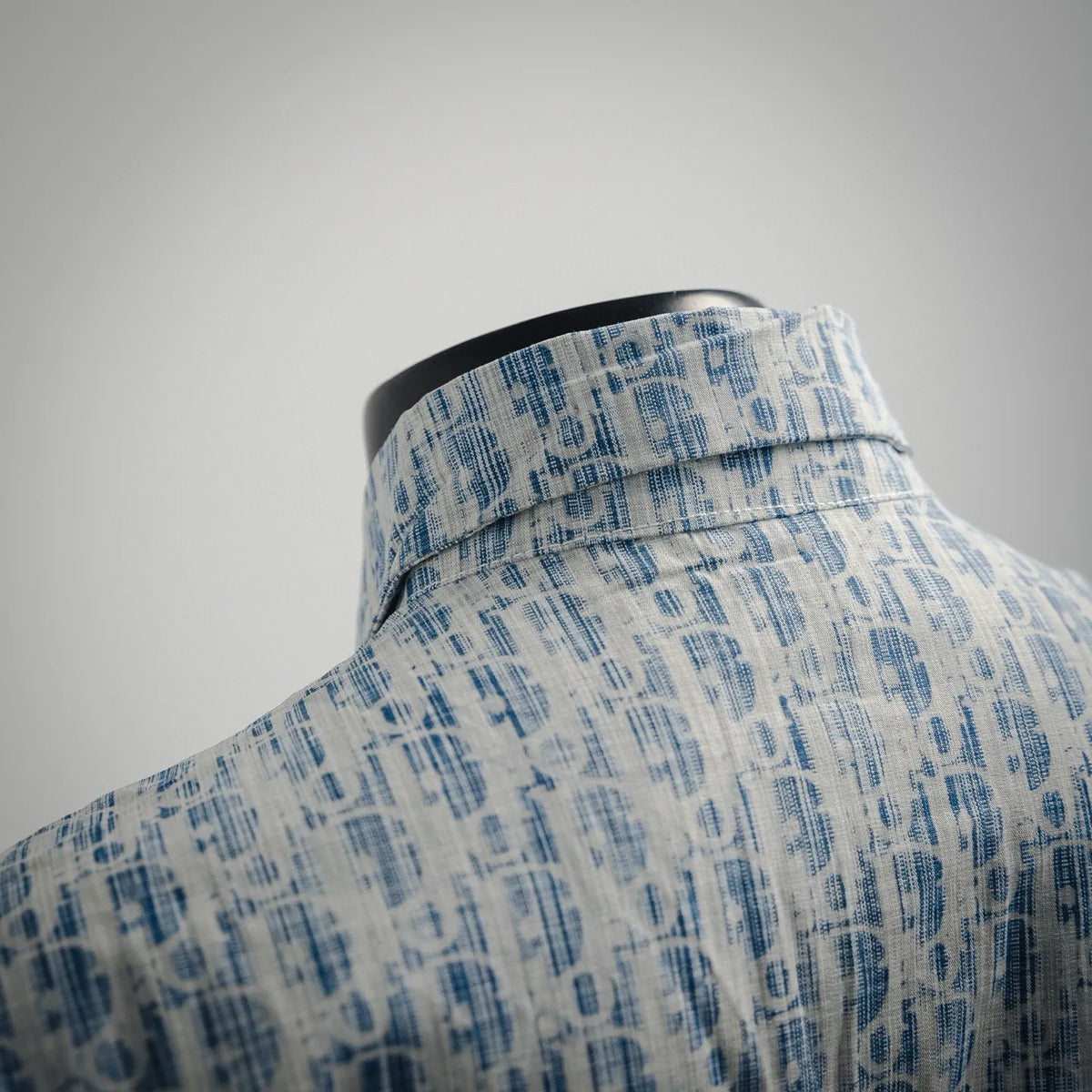 Light blue patterned long-sleeve shirt with folded stand collar and button placket.