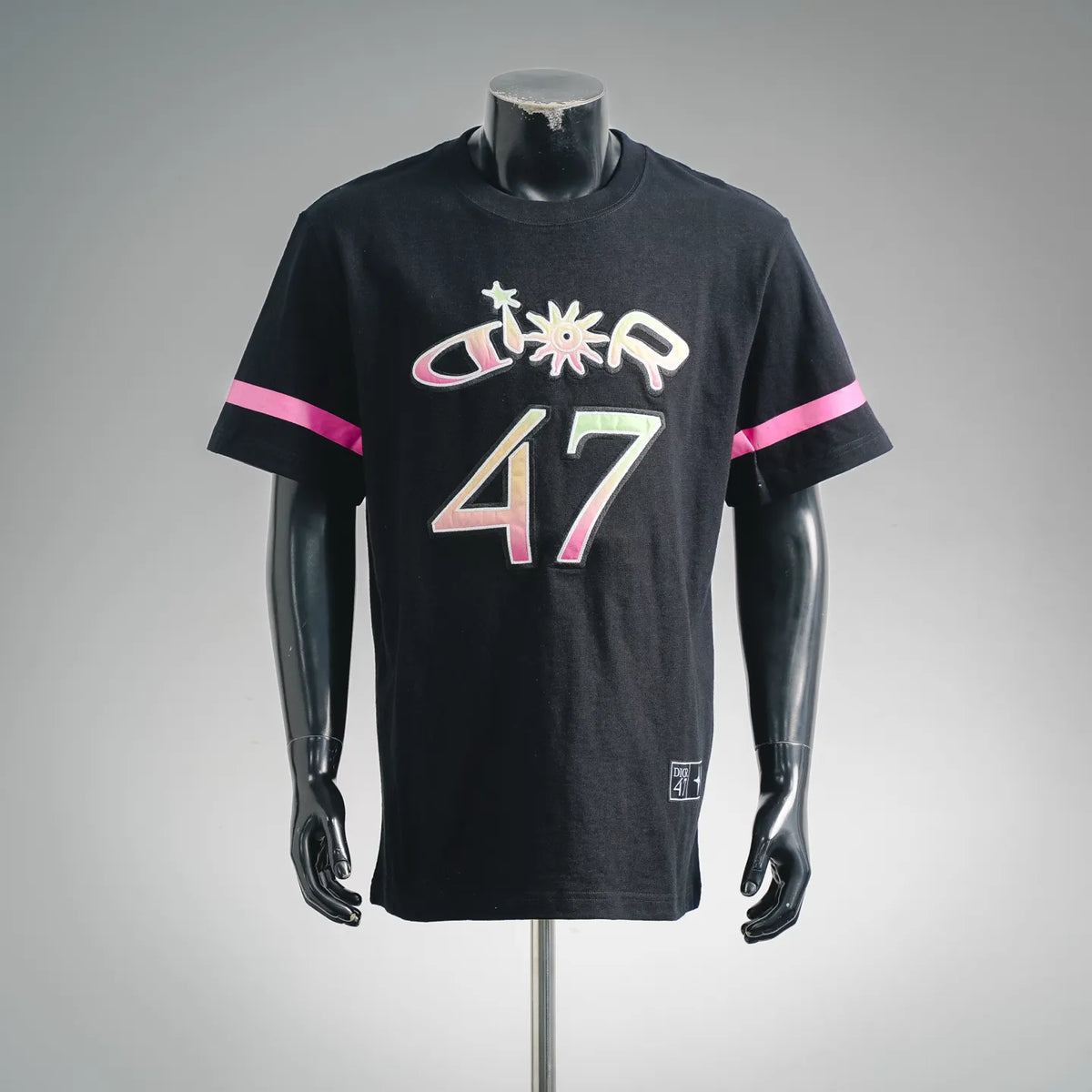 Black crewneck T-shirt with colorful "47" graphic and pink sleeve stripe
