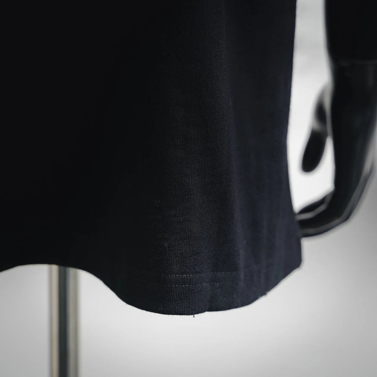Close-up of black T-shirt hem and fabric texture