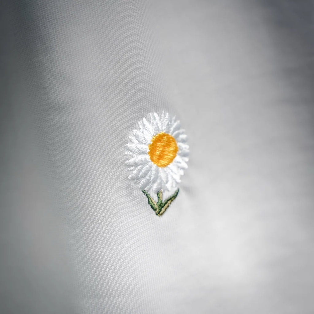 White T-shirt close-up of daisy embroidery on back panel