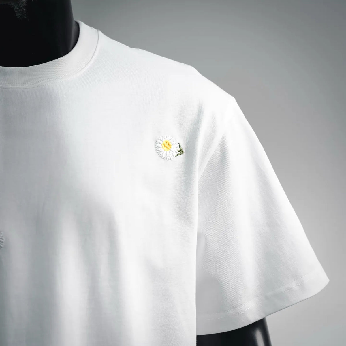 White T-shirt front view with single small daisy on left chest