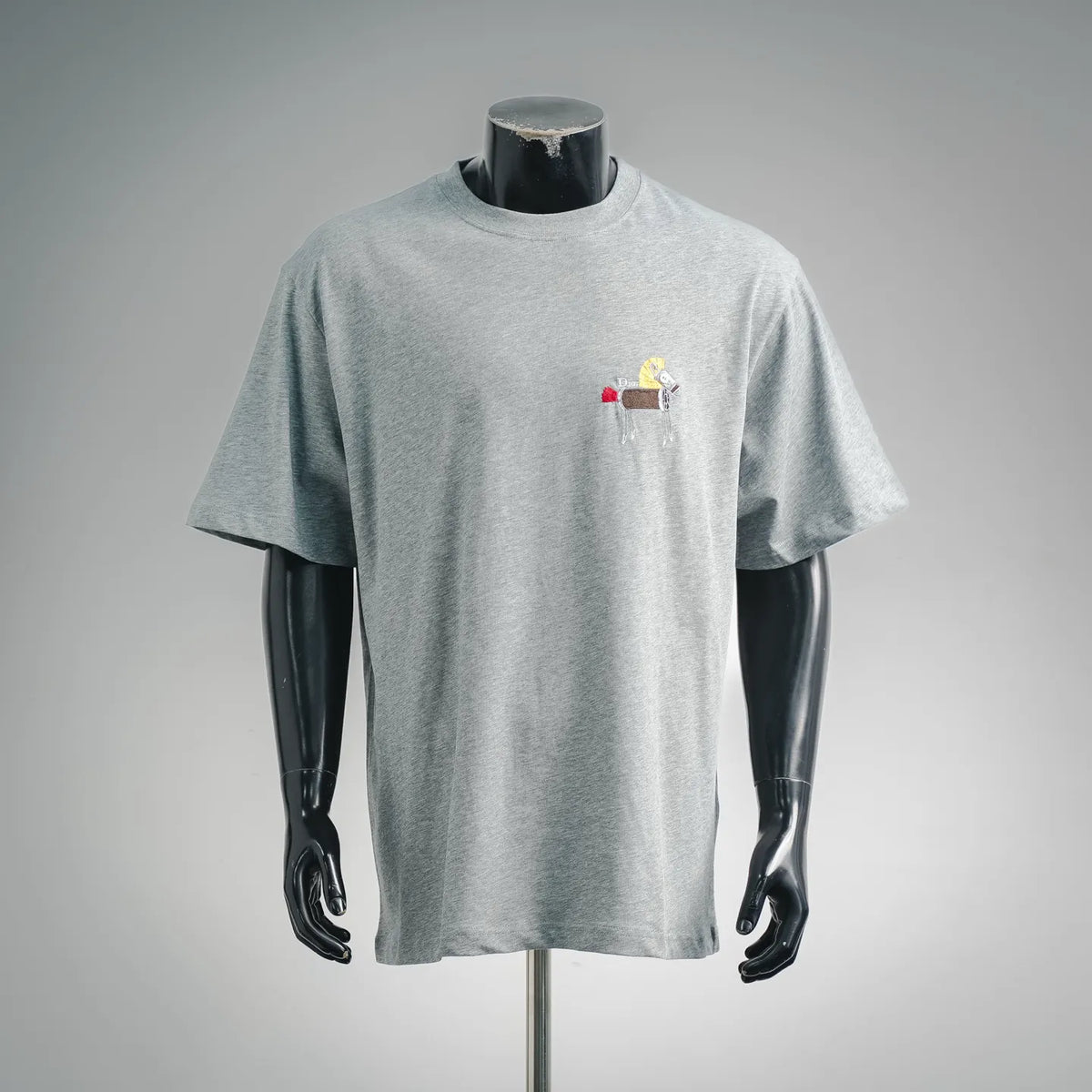 Heather gray crew-neck T-shirt with small embroidered patch and tassel detail