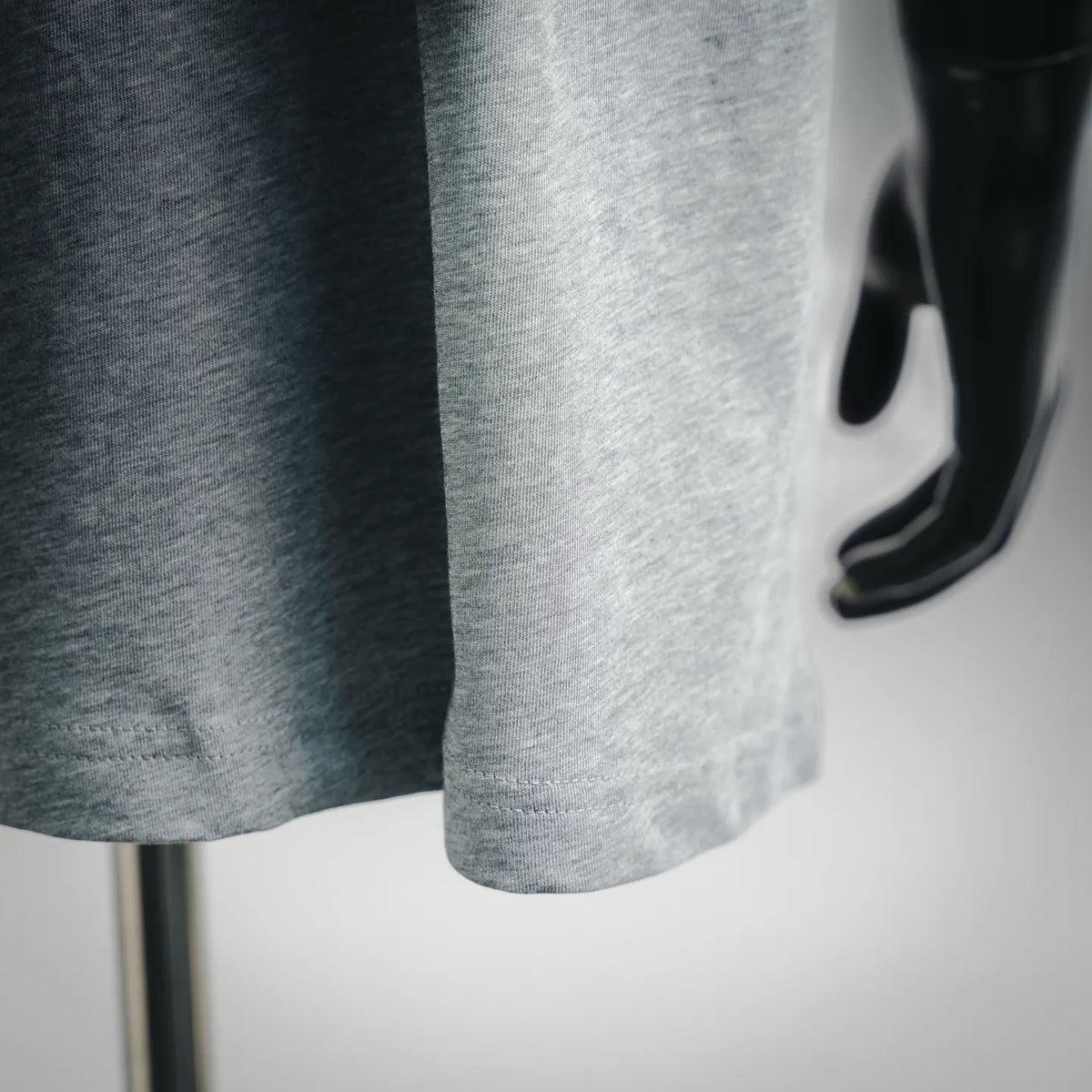 Heather gray T-shirt hem and side drape on a mannequin