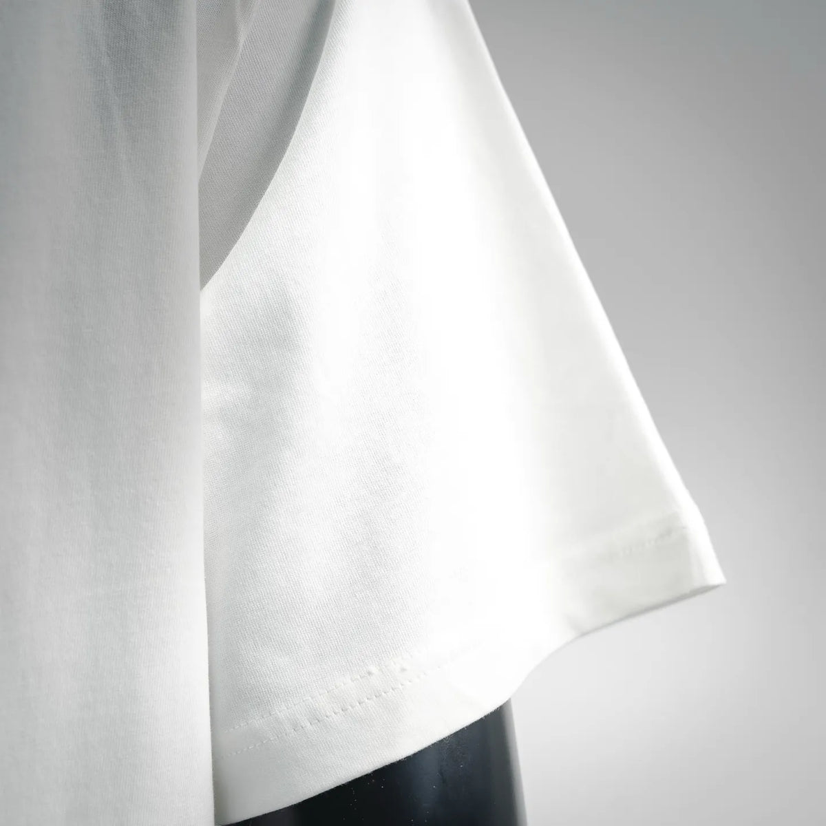 White crew-neck T-shirt side view with stitched hem and drape