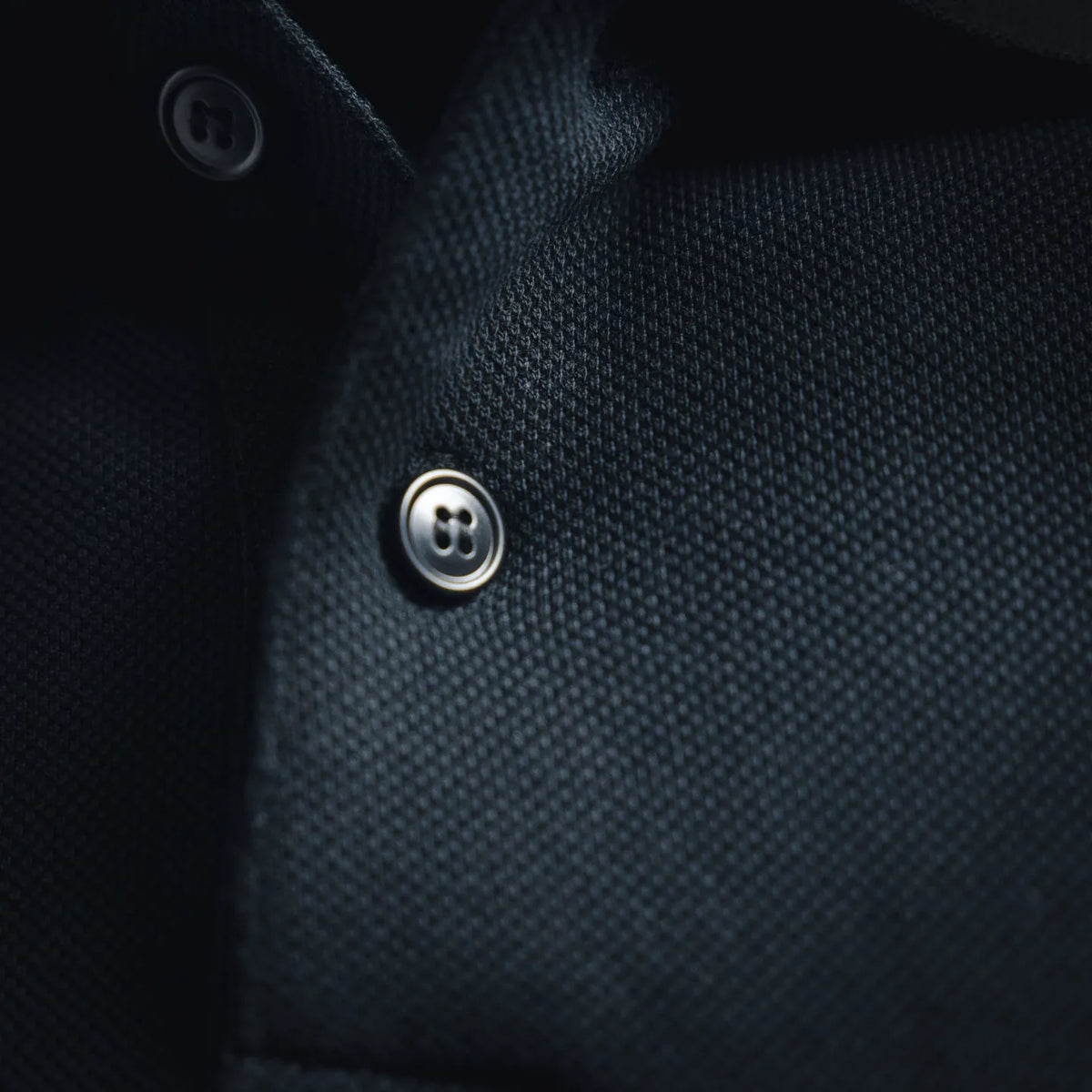 Close-up of navy polo button placket