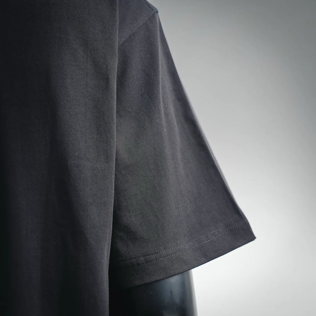 Black short-sleeve Dior T-shirt, close-up of fabric and sleeve hem