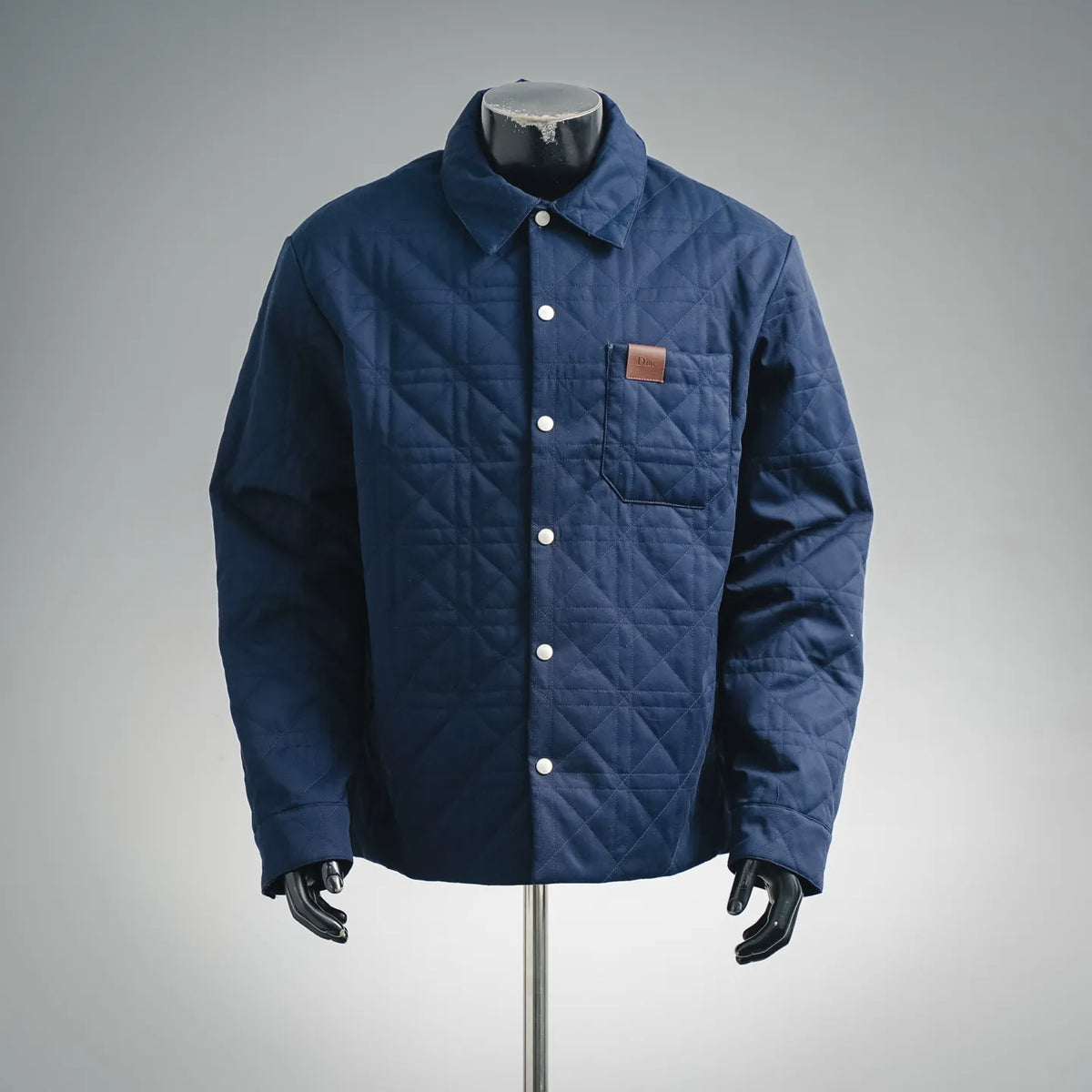 Blue quilted coat with button front, point collar, and chest pocket