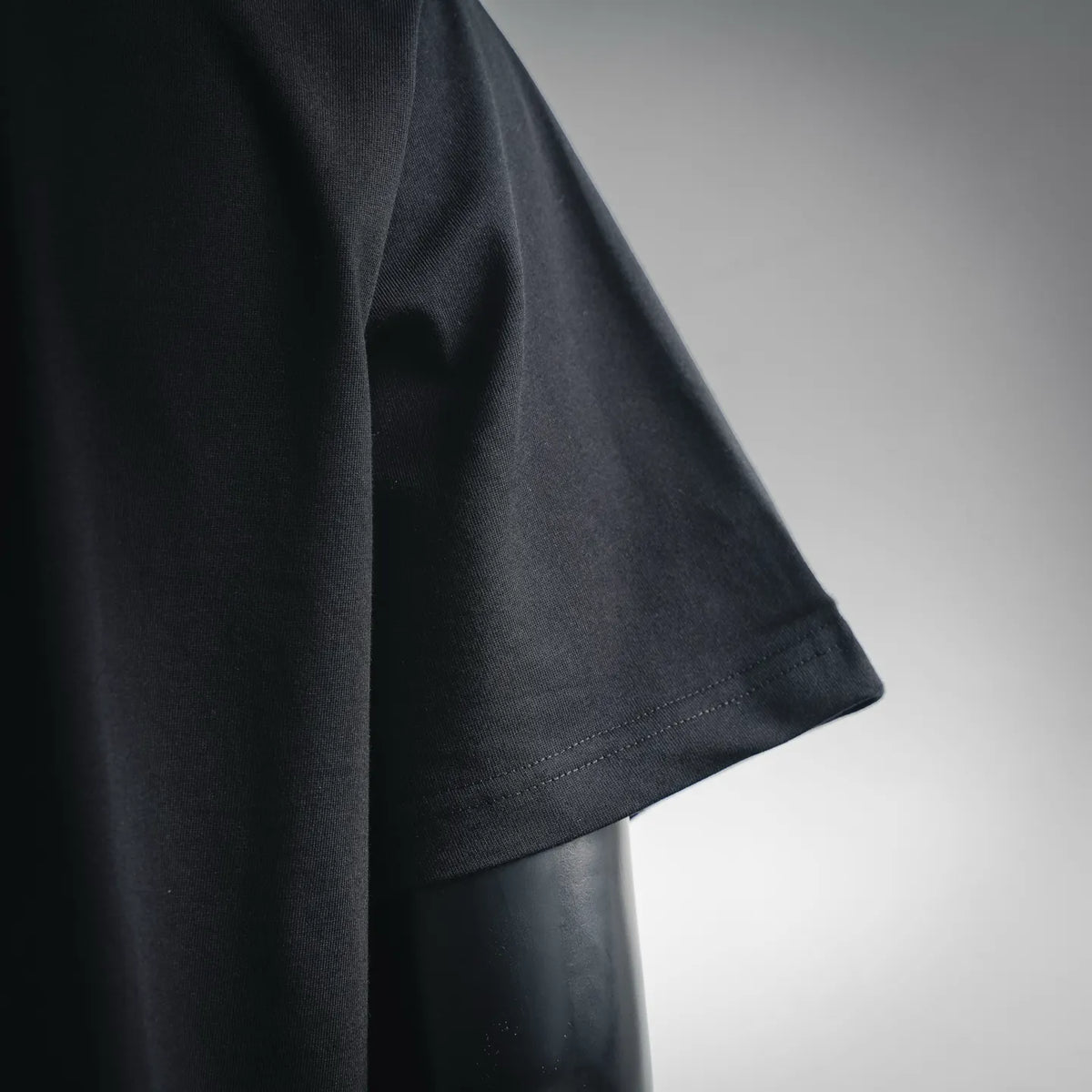 Black short sleeve T-shirt with stitched sleeve hem edge close-up