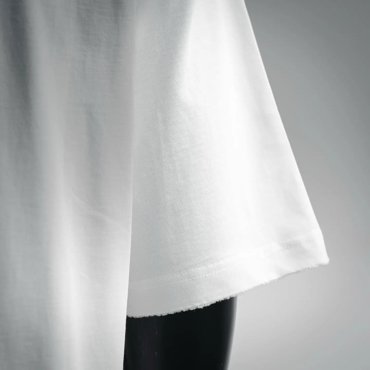 Dior white short-sleeve t-shirt side view with stitched hem and clean drape