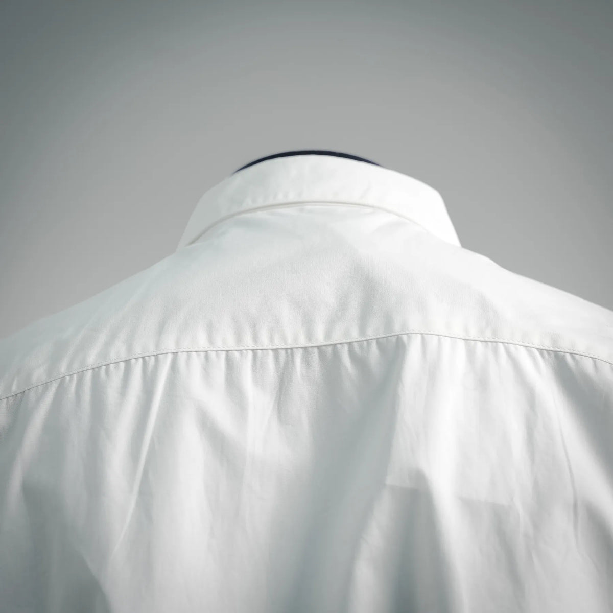 White shirt back yoke area close-up with stitched seam detail