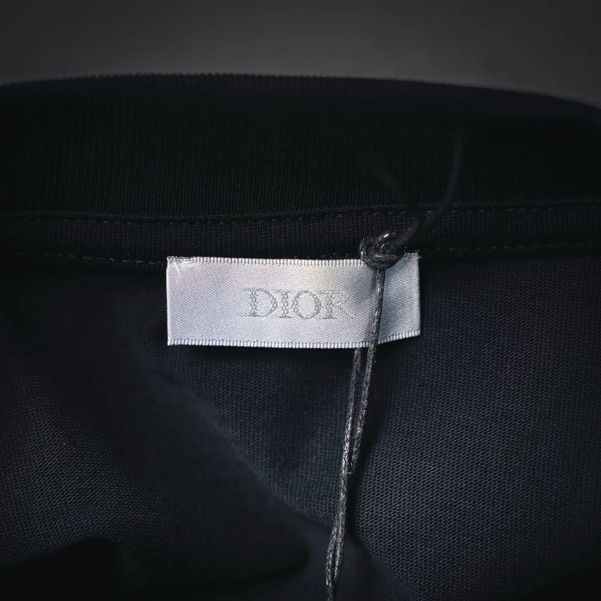 Dior fabric label at neckline on dark short-sleeve T-shirt