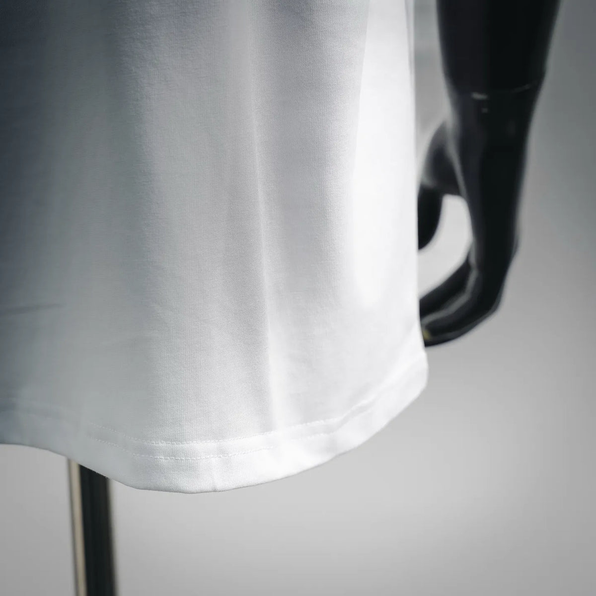 White short-sleeve T-shirt fabric close-up, hem and side detail