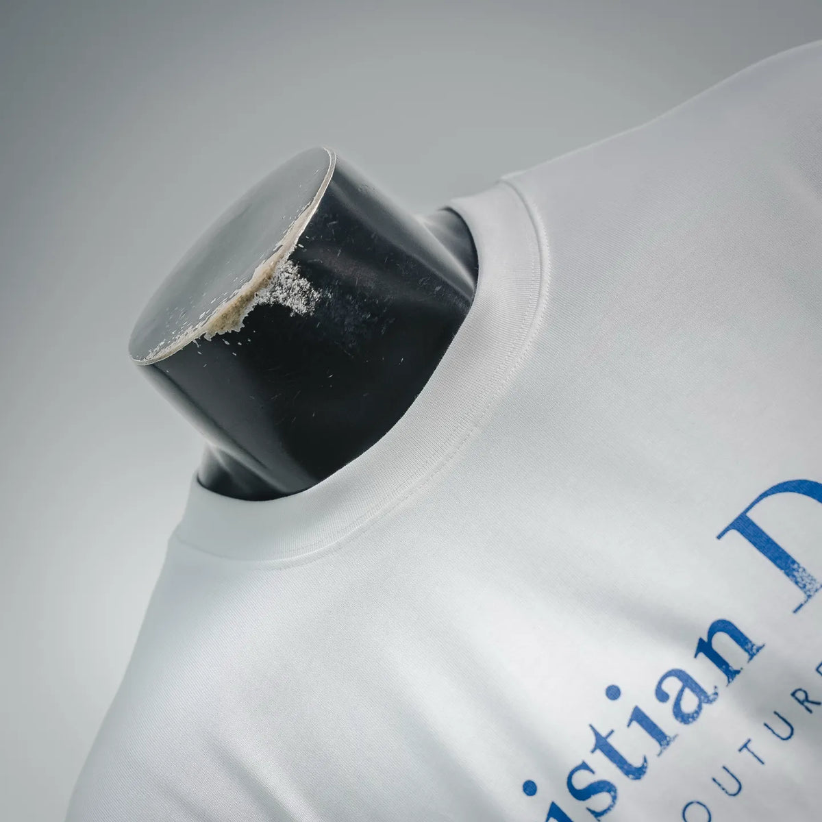 White T-shirt neckline close-up with blue logo print detail