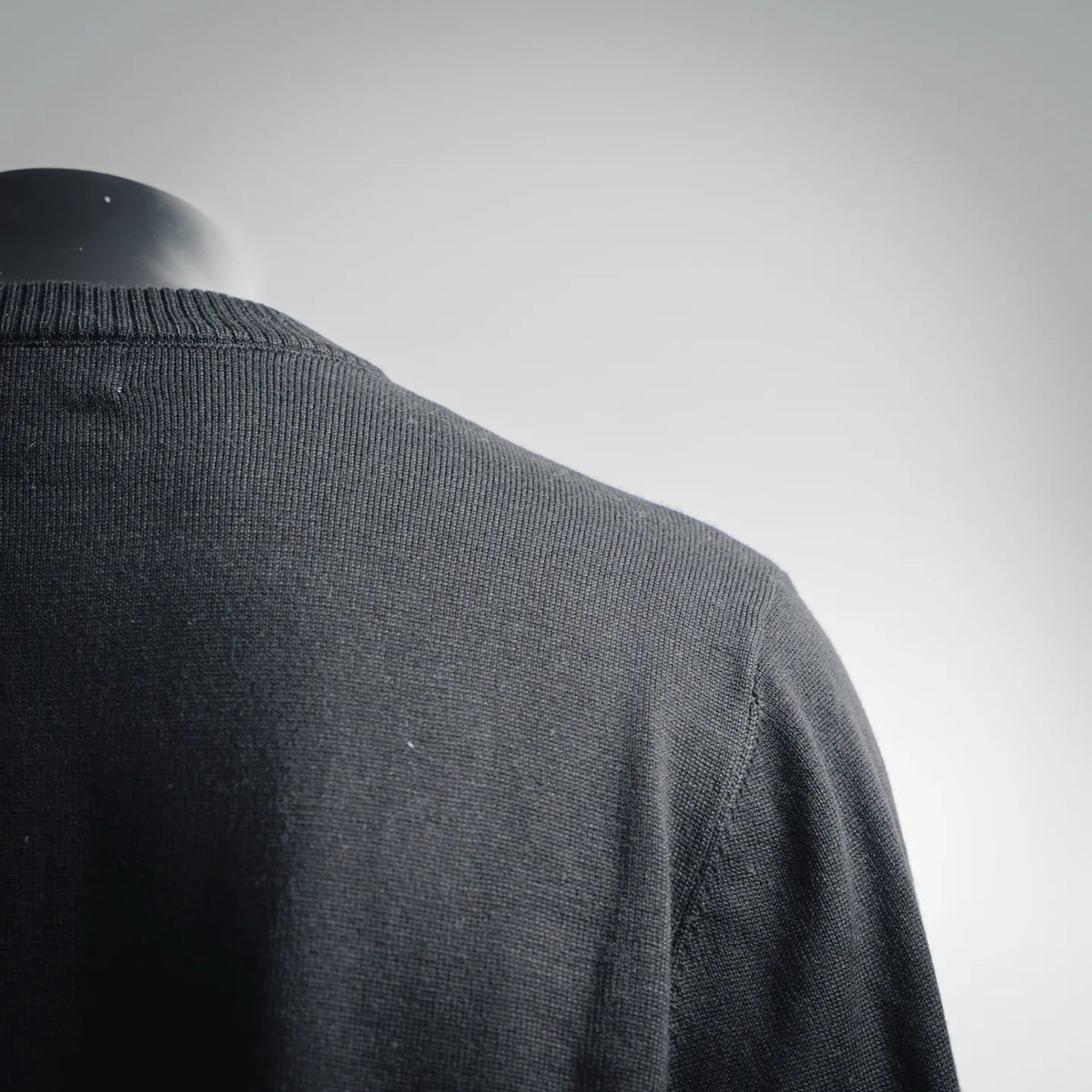 Black knit sweater shoulder seam with ribbed collar