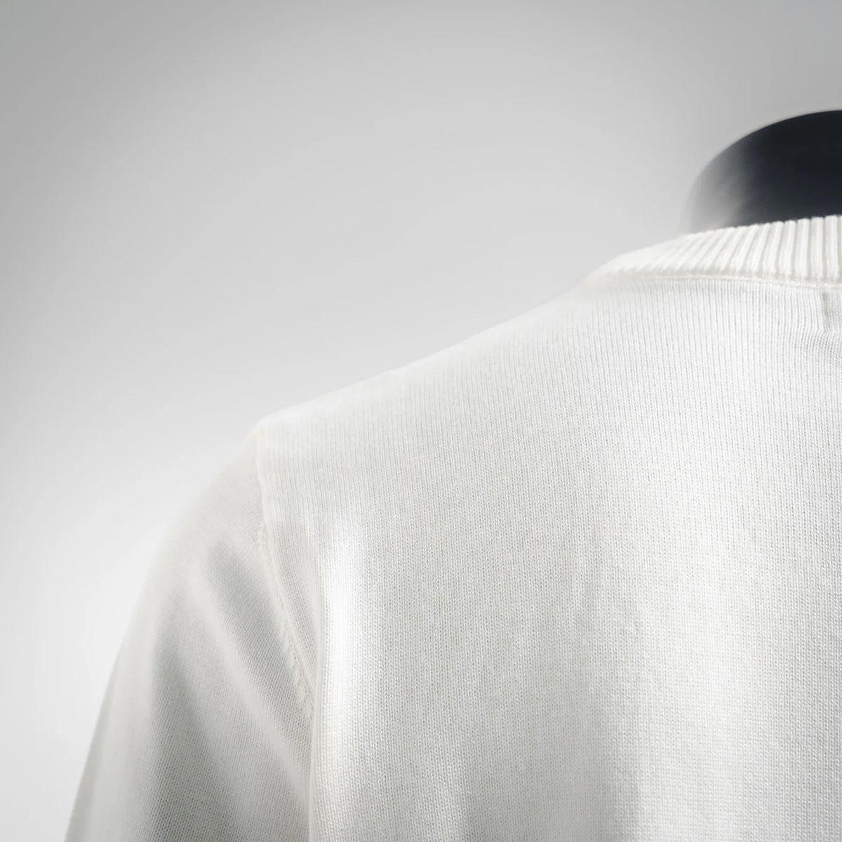 White knit sweater close-up of ribbed collar and upper back