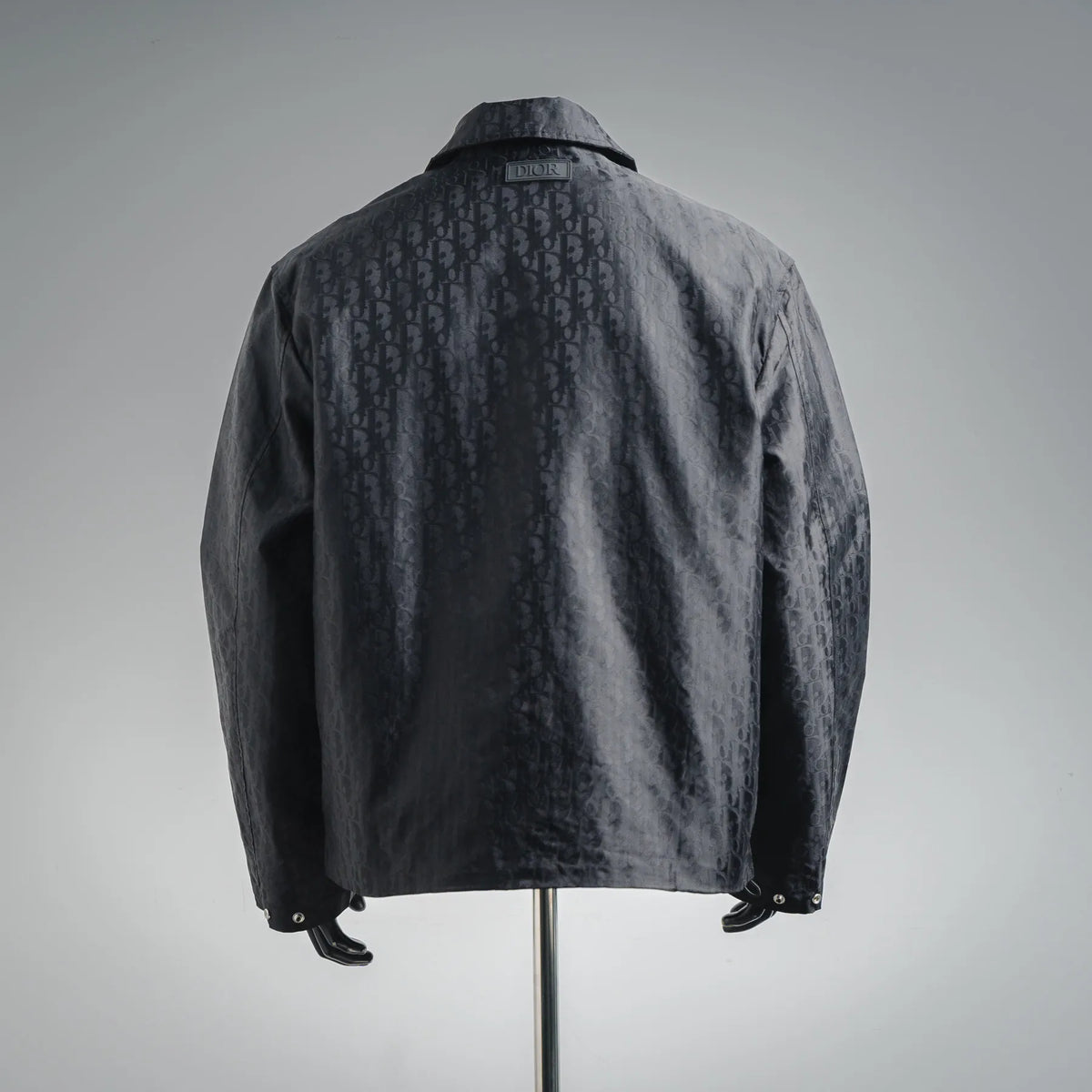Dark monogram jacket coat from the back with stand collar and button detail