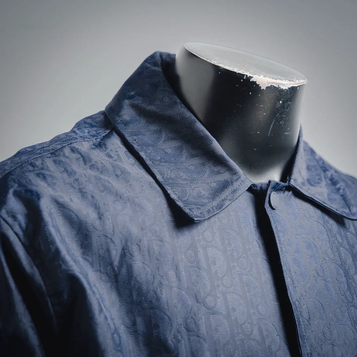 Dior dark blue coat collar with button placket and repeating logo pattern