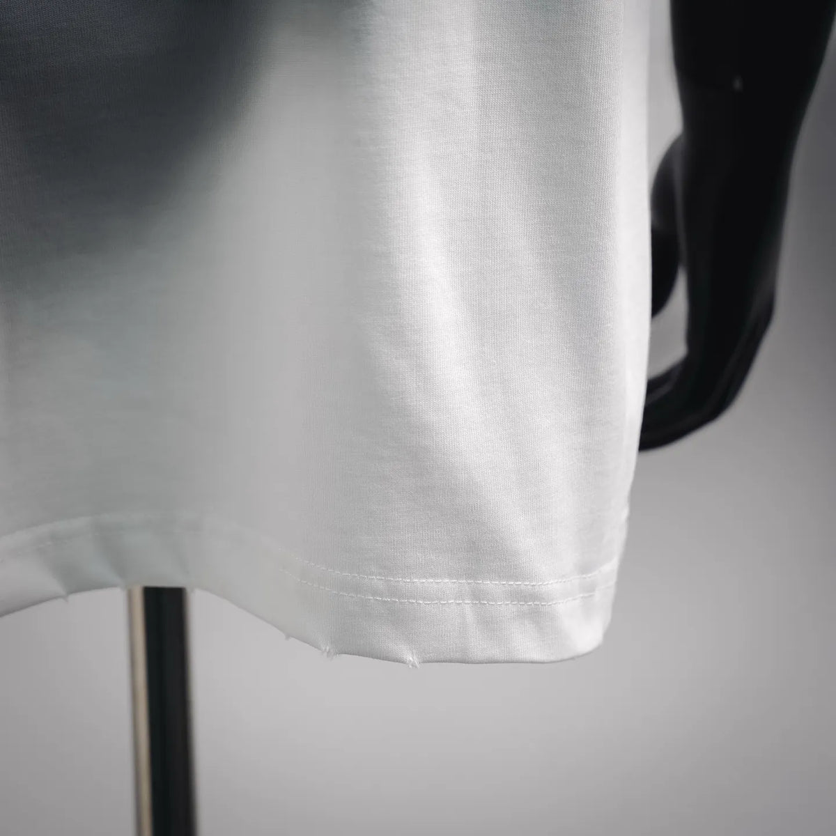 White Dior T-shirt lower hem with visible stitching and clean edge finish