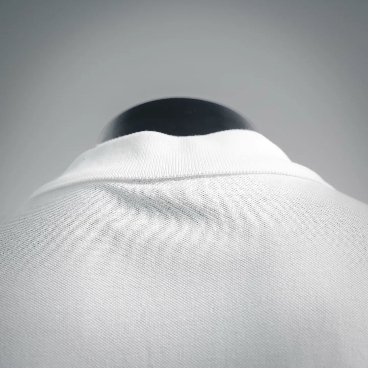 White polo shirt collar close-up with ribbed neckline detail.