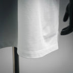 White polo shirt sleeve and lower hem close-up with neat stitched edge.